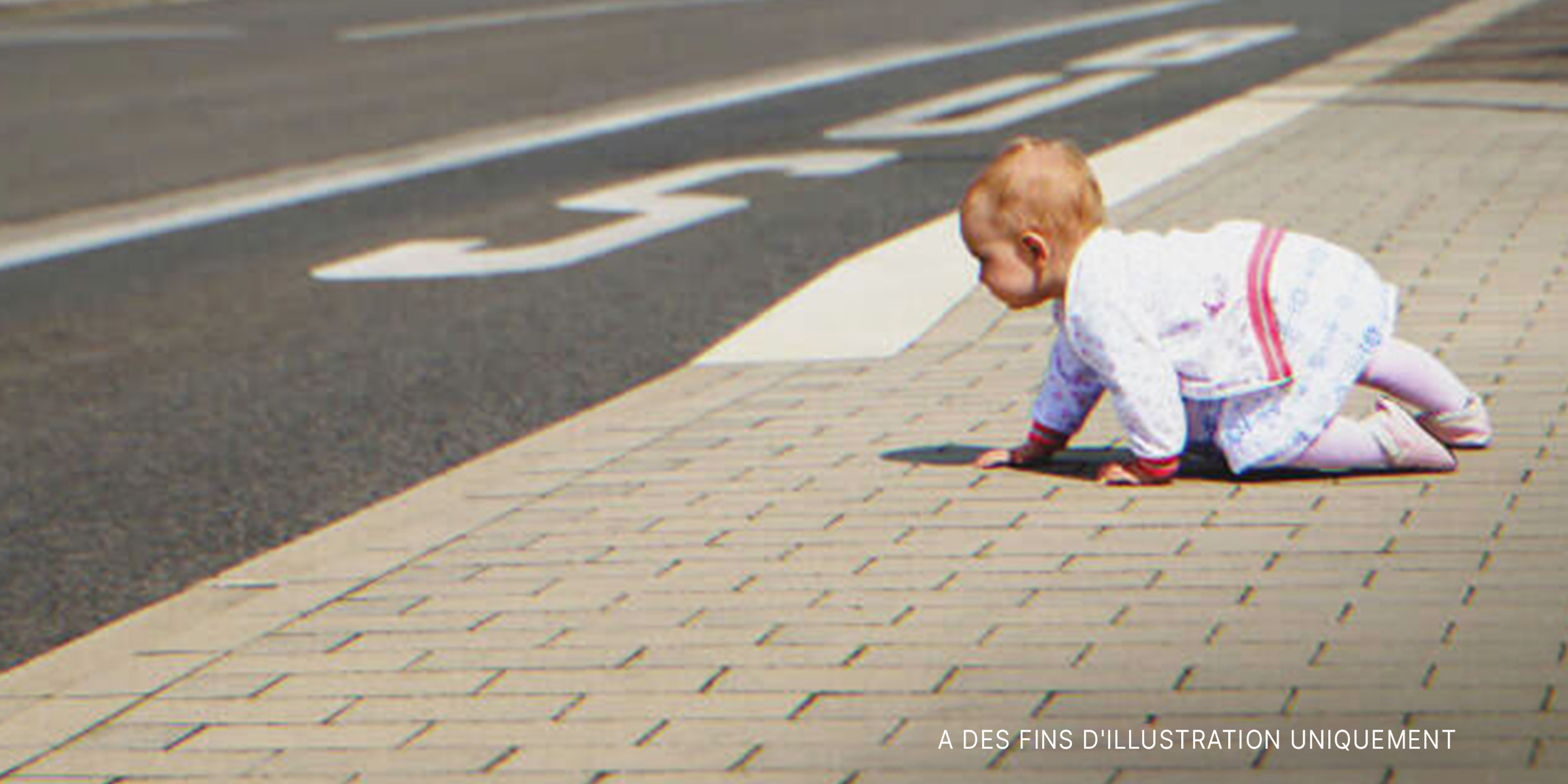 Un bébé rampant sur un trottoir | Source : Shutterstock