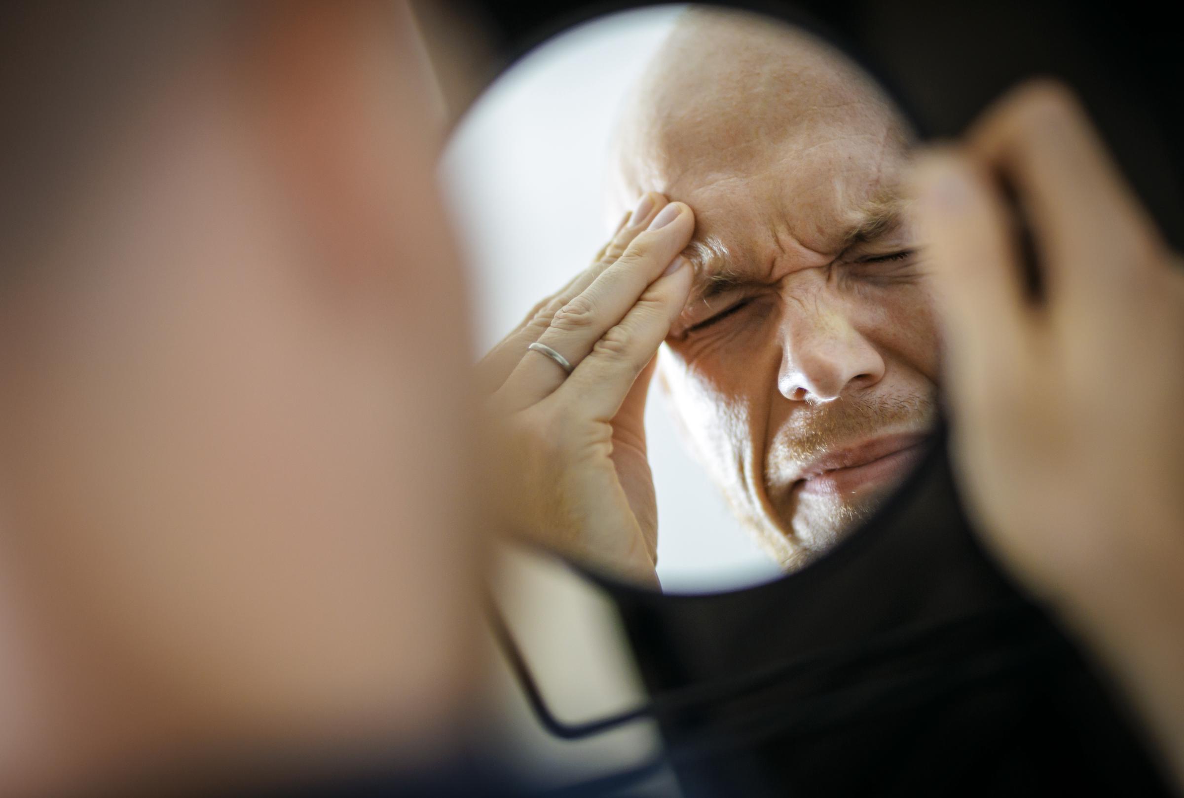 Image symbolique représentant les migraines et les maux de tête : homme se tenant la tête douloureuse dans l'inconfort | Source : Getty Images