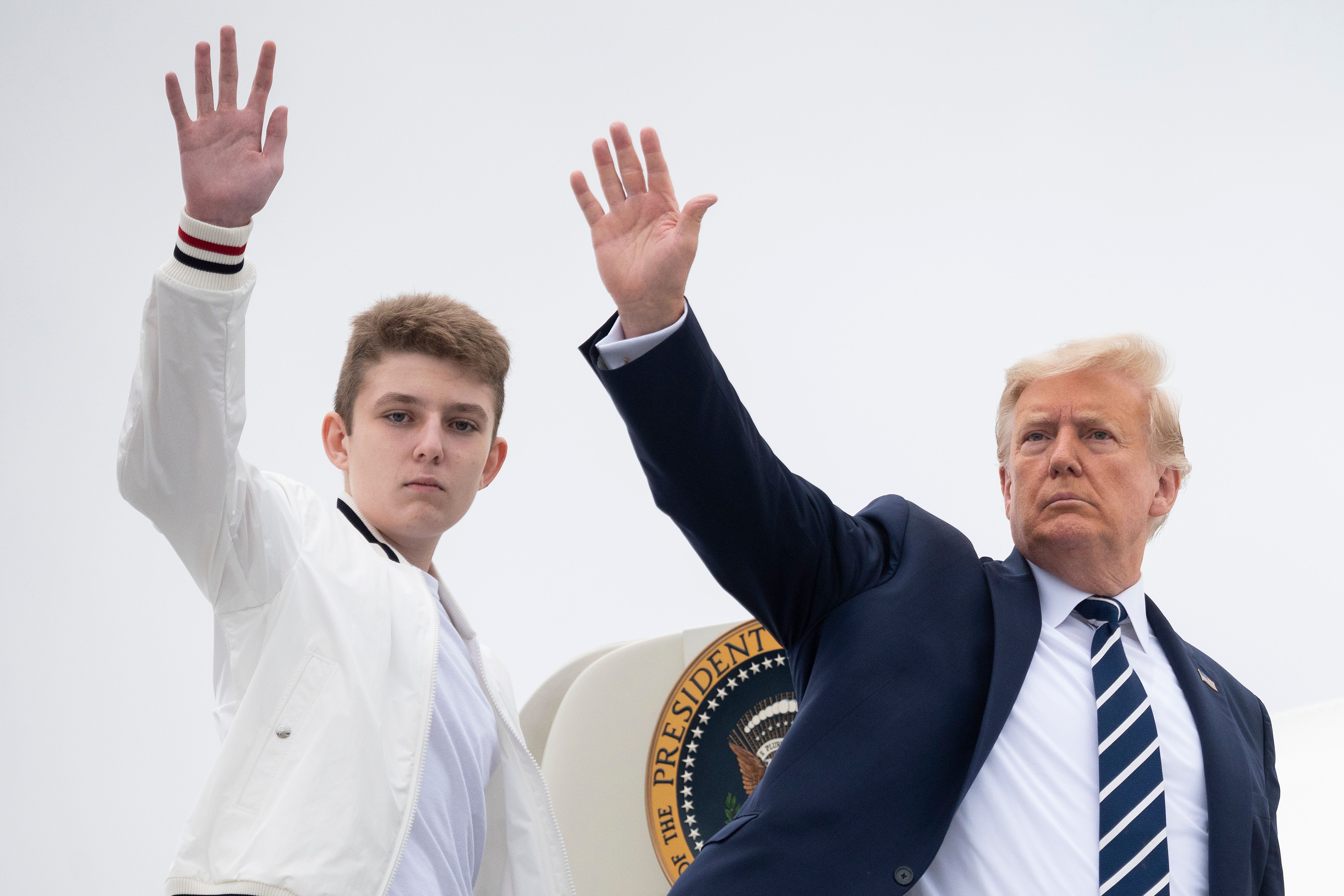 Le président américain Donald Trump et Barron saluent alors qu'ils montent à bord d'Air Force One à l'aéroport municipal de Morristown, dans le New Jersey, le 16 août 2020. | Source : Getty Images