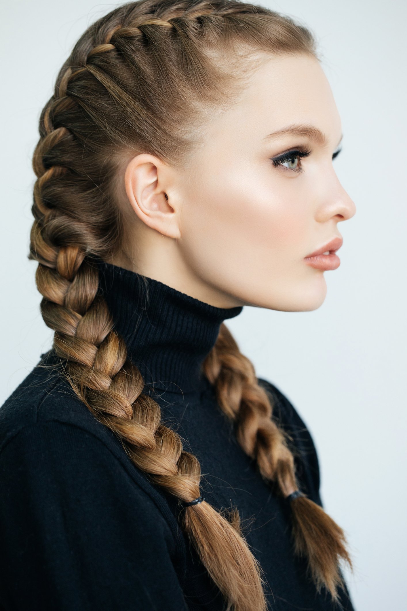 Portrait d'une jeune femme vu de profil coiffée d'une grosse tresse | Source : Getty Images