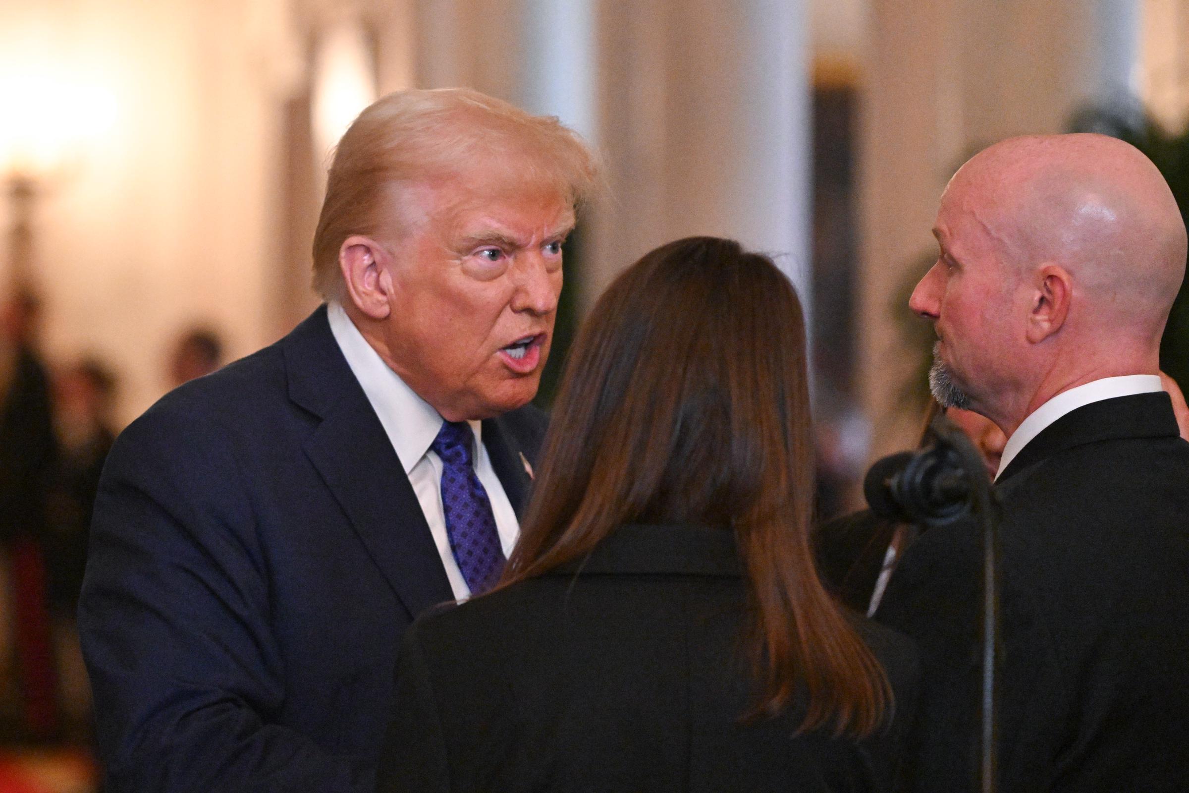 Le président américain Donald Trump s'entretient avec Allyson Phillips, mère de Laken Riley, et John Phillips, beau-père de Laken Riley, avant de signer la loi Laken Riley dans la salle Est de la Maison Blanche à Washington, D.C., le 29 janvier 2025. | Source : Getty Images