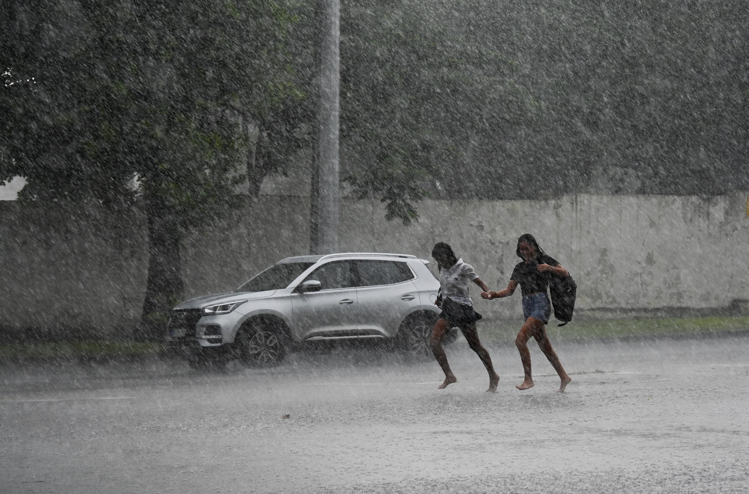 Des personnes courent sous une pluie torrentielle à La Havane en raison du passage de l'ouragan Milton, le 9 octobre 2024 | Source : Getty Images