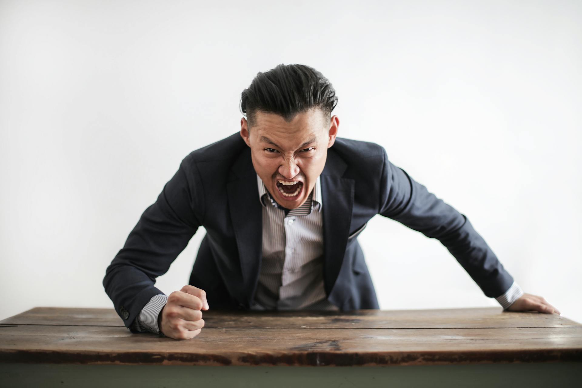 Un homme furieux frappe un bureau | Source : Pexels