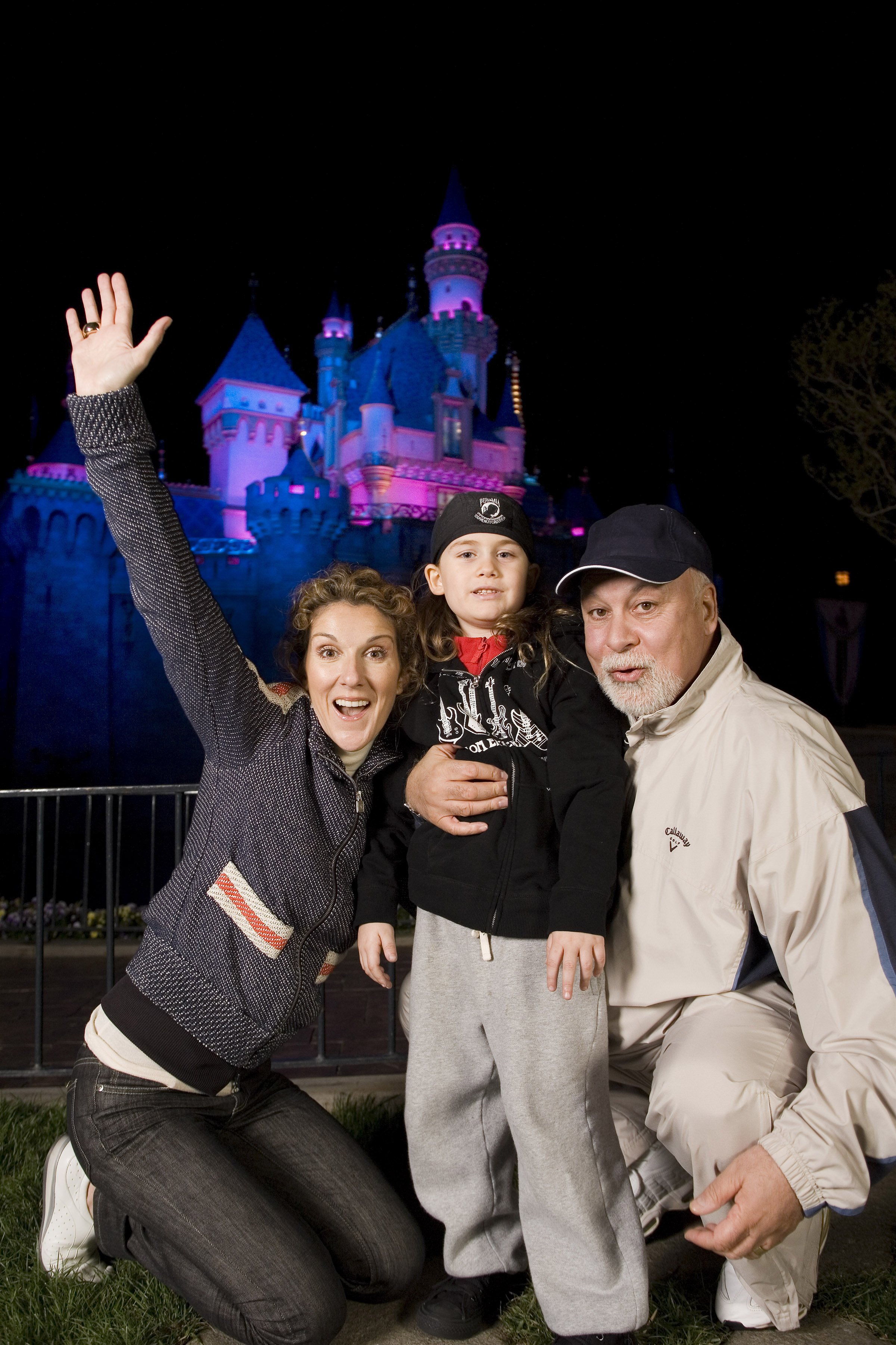 Céline Dion, son fils René-Charles, 6 ans, et son mari René Angelil devant le château de la Belle au bois dormant à Disneyland à Anaheim, en Californie, mercredi soir. | Source : Getty Images