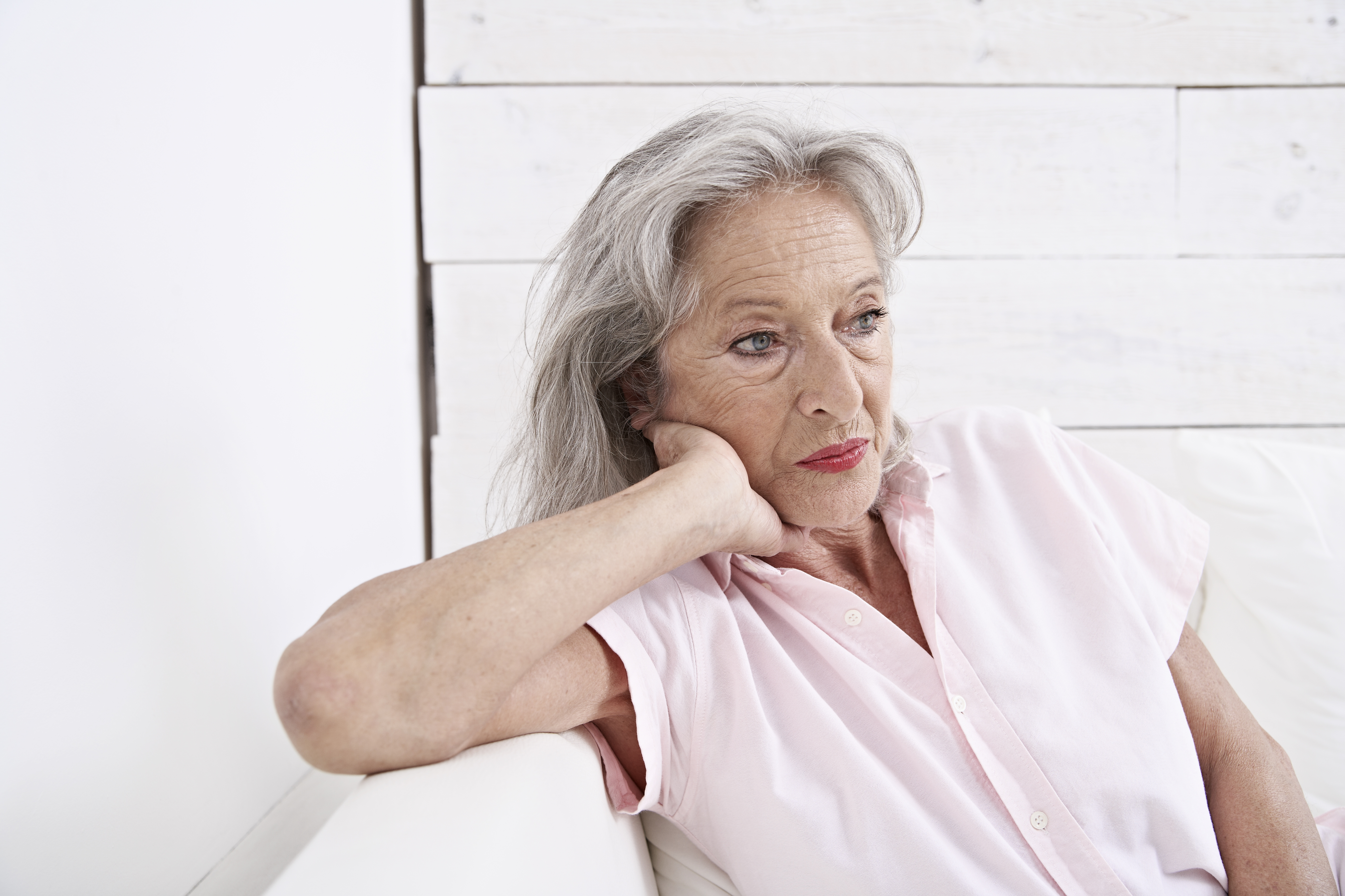 Une femme âgée triste assise sur un canapé | Source : Getty Images