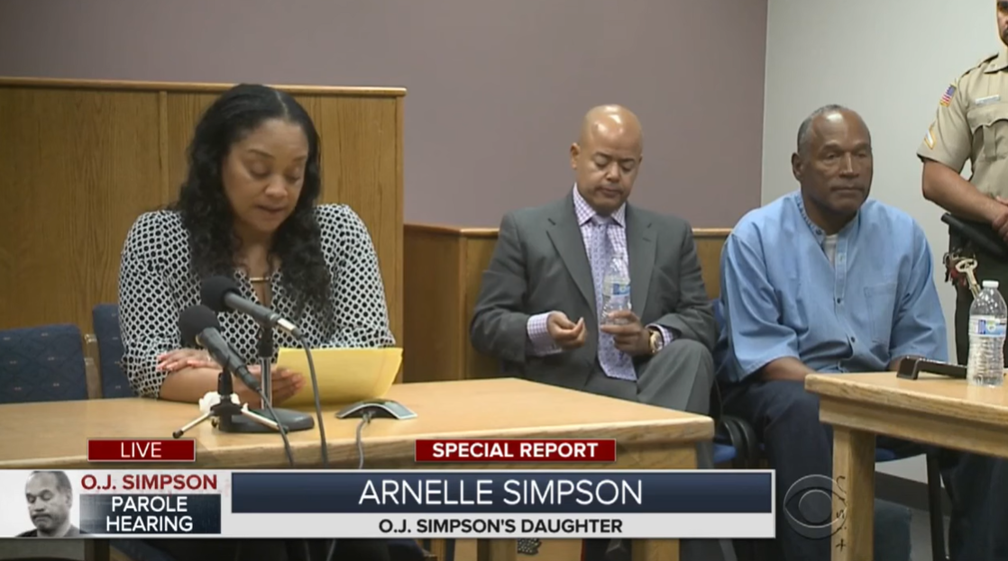 Arnelle Simpson parle devant une commission de libération conditionnelle tandis qu'O.J. Simpson écoute dans le coin de la pièce lors d'une audience de la commission de libération conditionnelle en 2017 dans le Nevada. | Source : YouTube/CBSNewYork