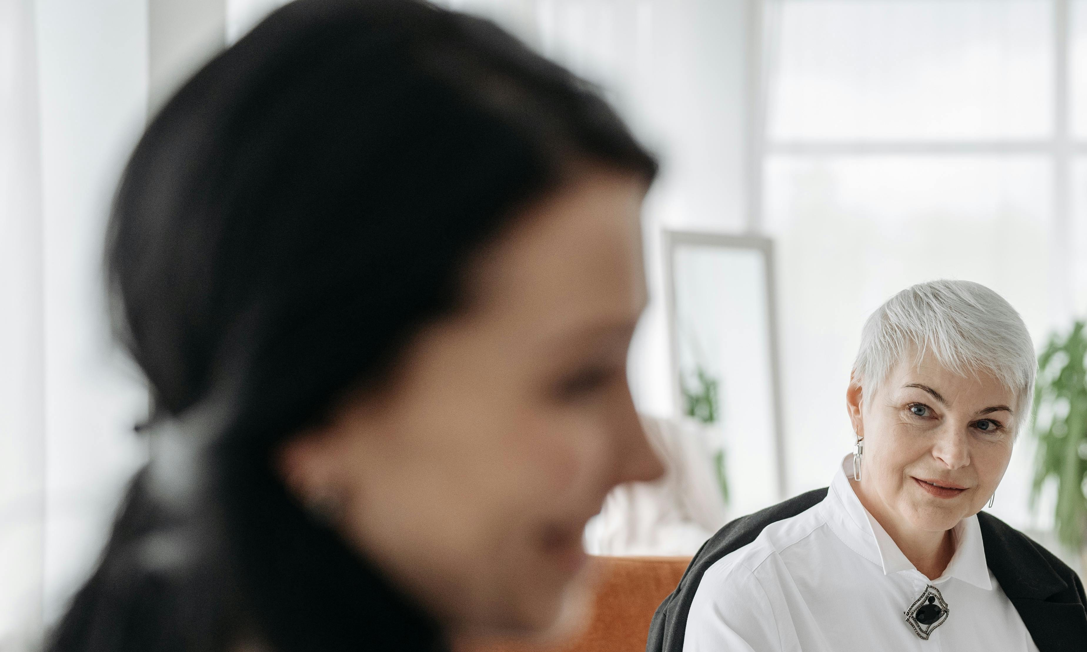 Olivia chats with an elderly woman while observing the busy airport scene | Source: Pexels