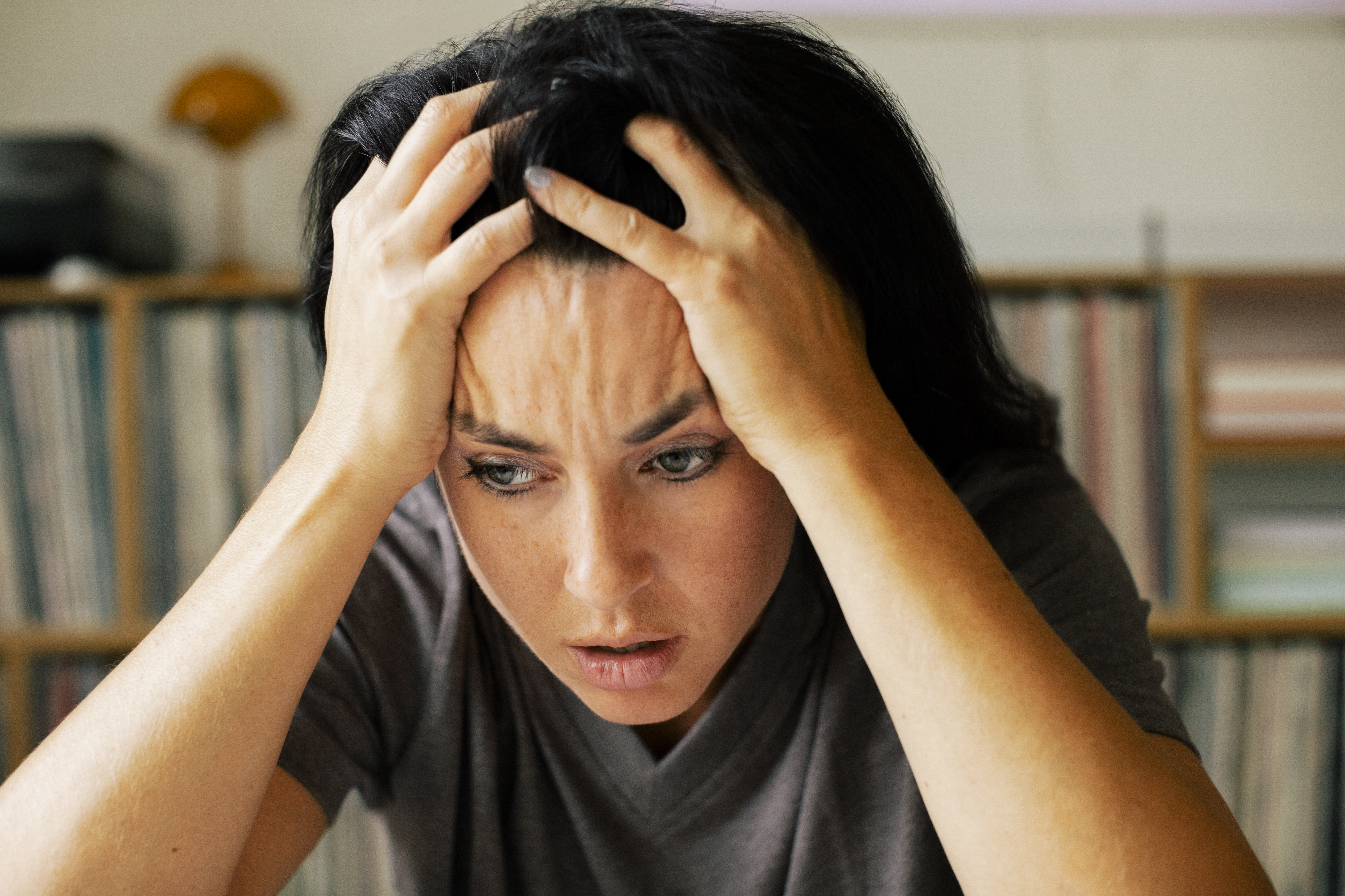 Femme stressée, la tête dans les mains à la maison | Source : Getty Images