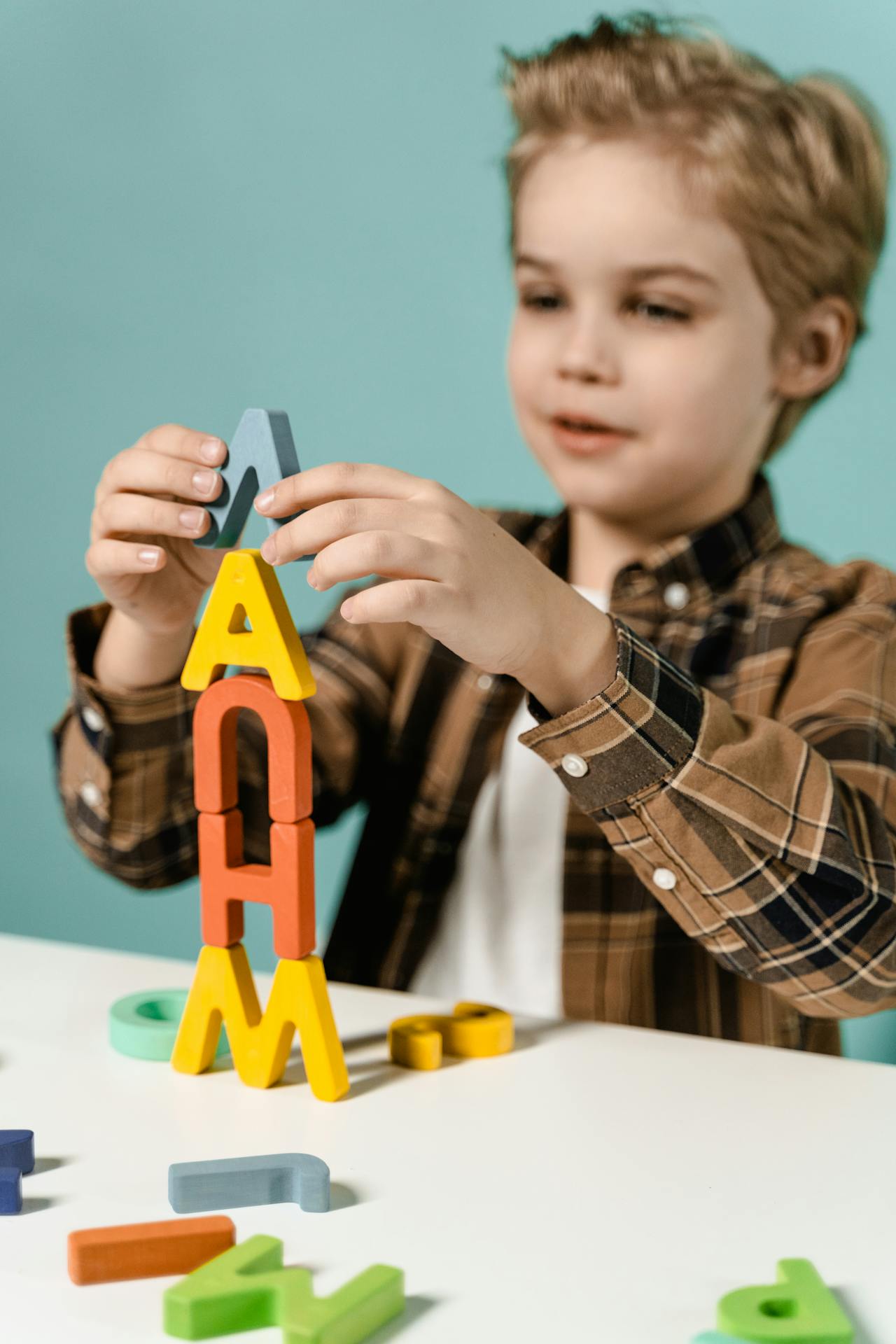 Un petit garçon qui empile des blocs de lettres | Source : Pexels