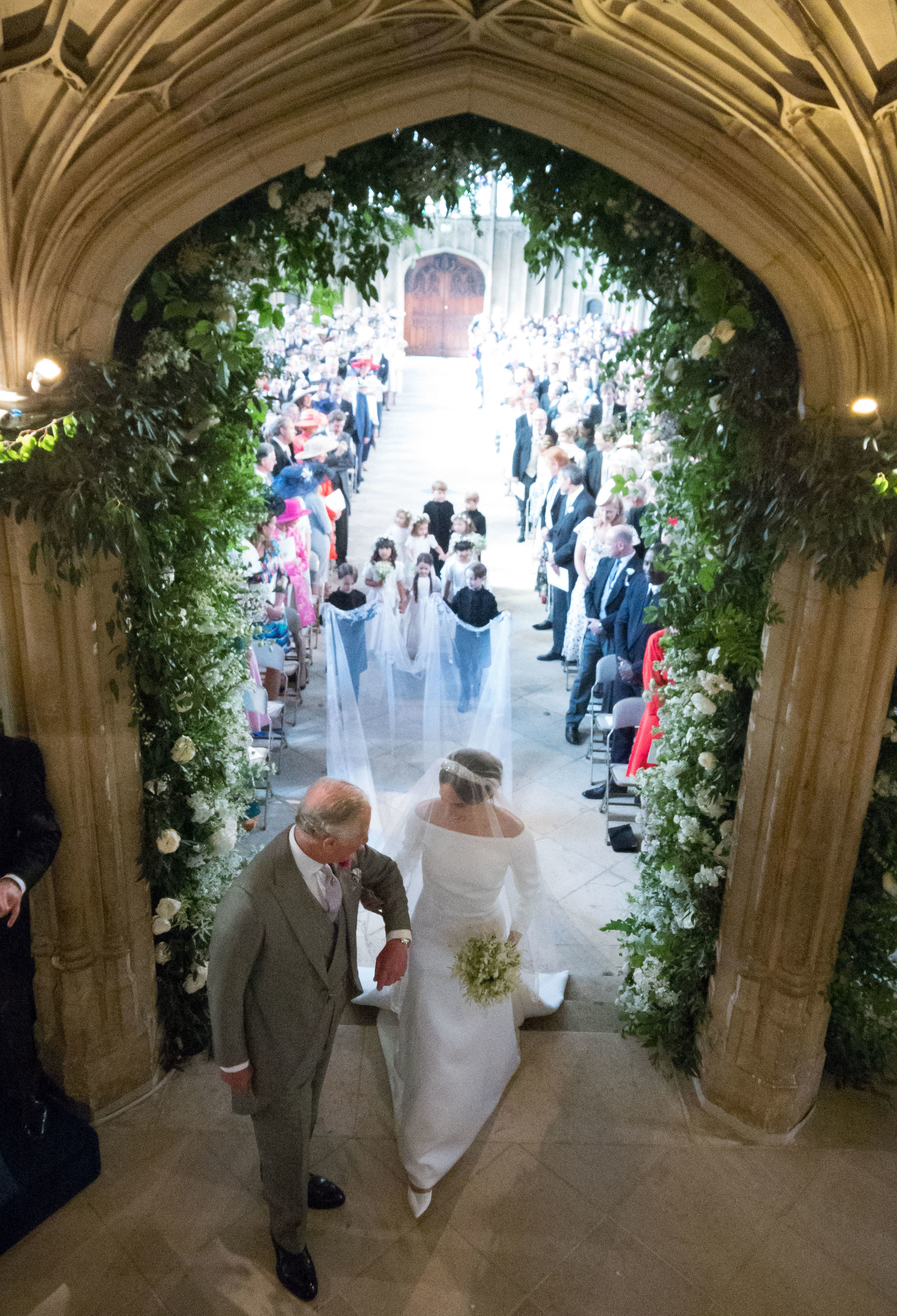 Le roi Charles III conduisant Meghan Markle à l'autel de la chapelle Saint-Georges, le 19 mai 2018 à Windsor, en Angleterre. | Source :  Getty Images