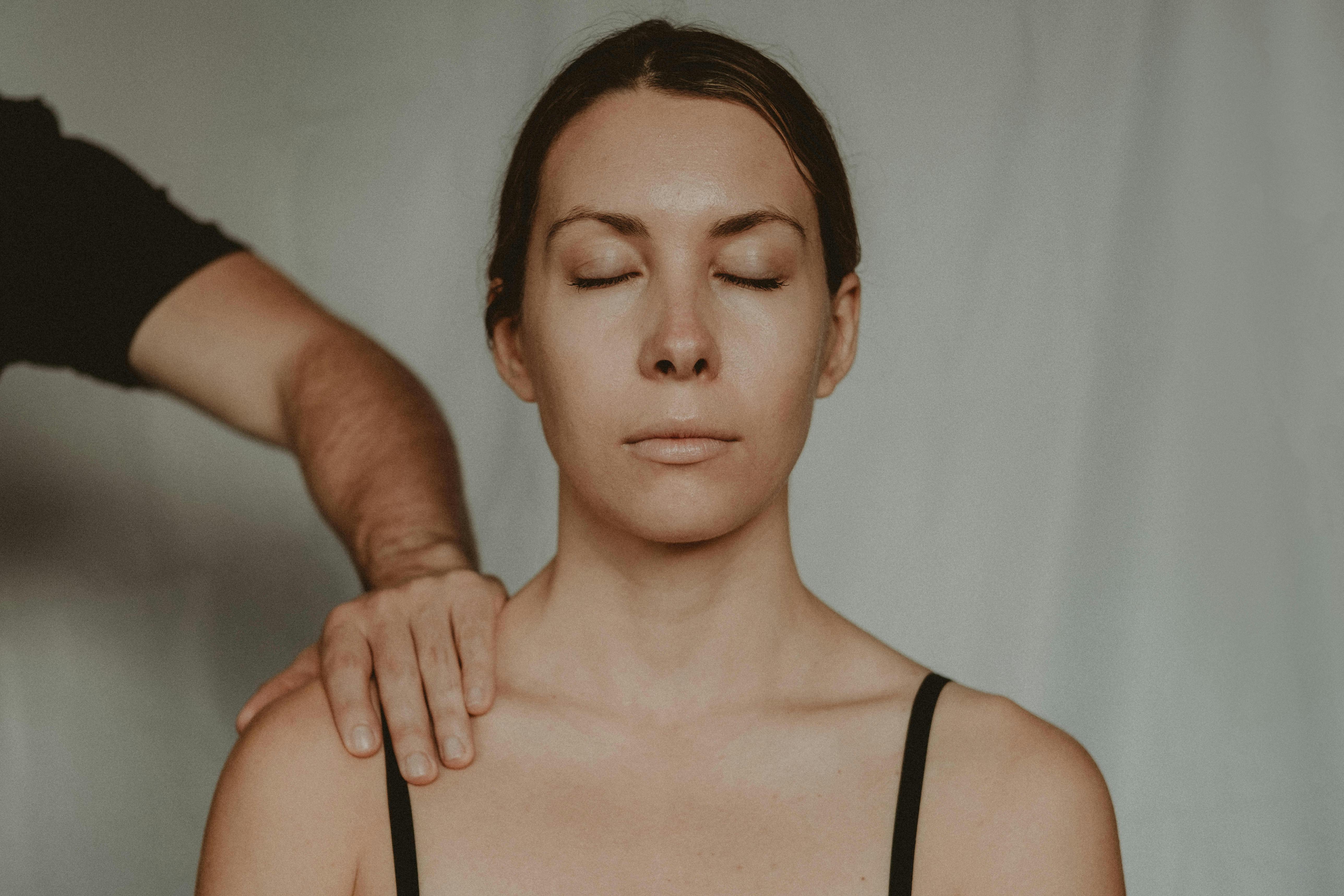 A woman with a man's hand on her shoulder | Source: Pexels