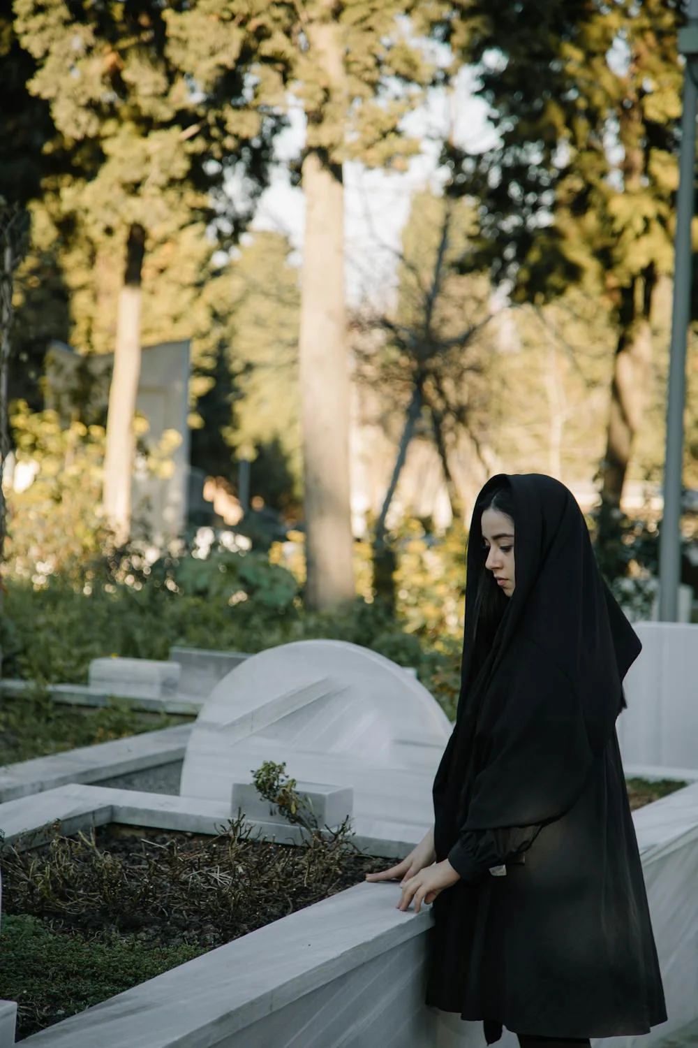 Une femme en noir dans un cimetière ⏐ Source : Pexels