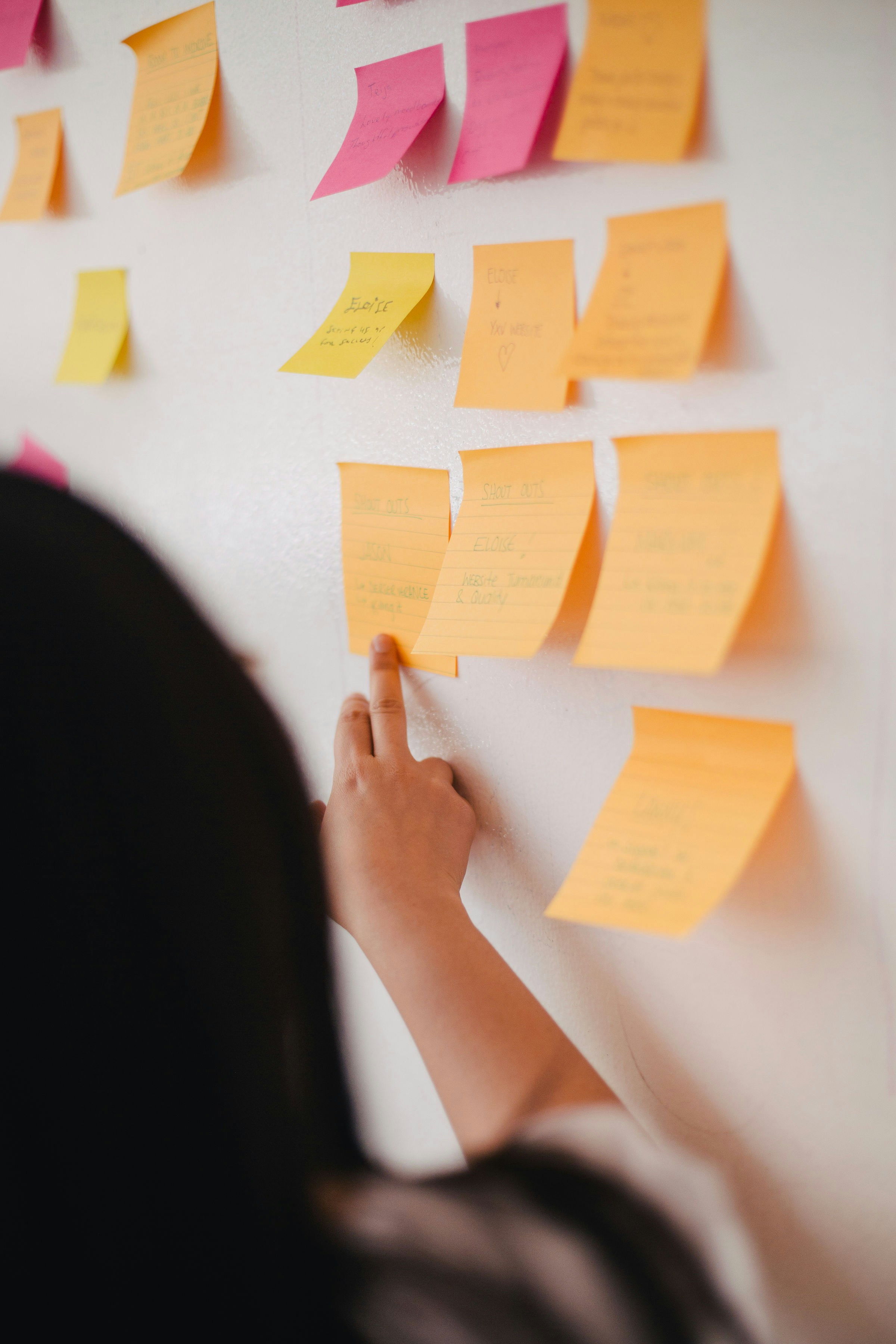 Une femme regarde des notes autocollantes | Source : Unsplash