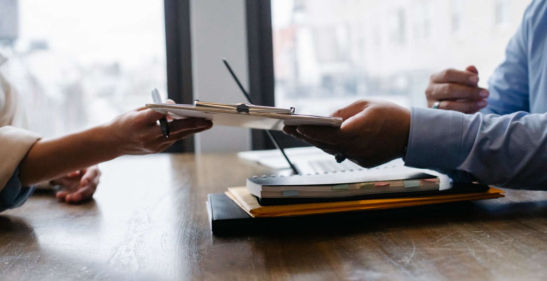 Une femme transmettant son curriculum vitae à un employeur | Source : Pexels