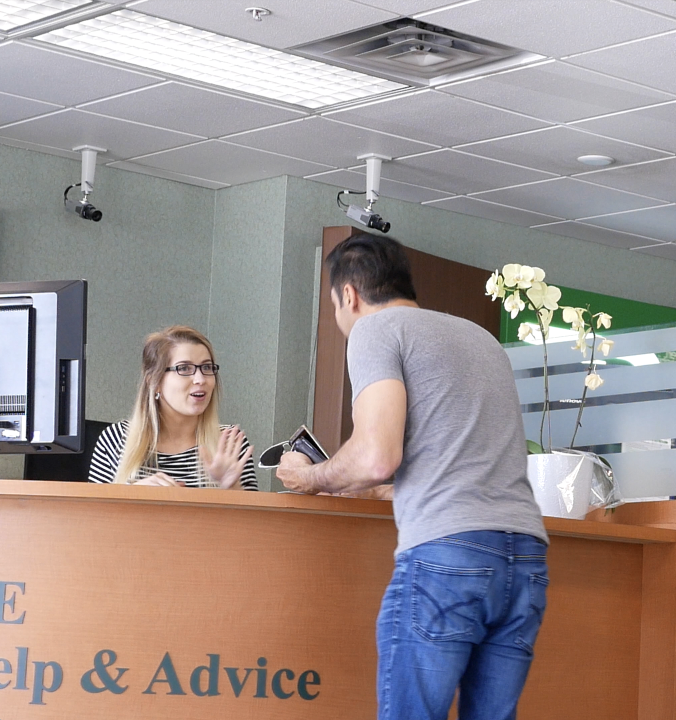 Hombre de pie junto a la atención al cliente en el banco | Fuente: Shutterstock.com