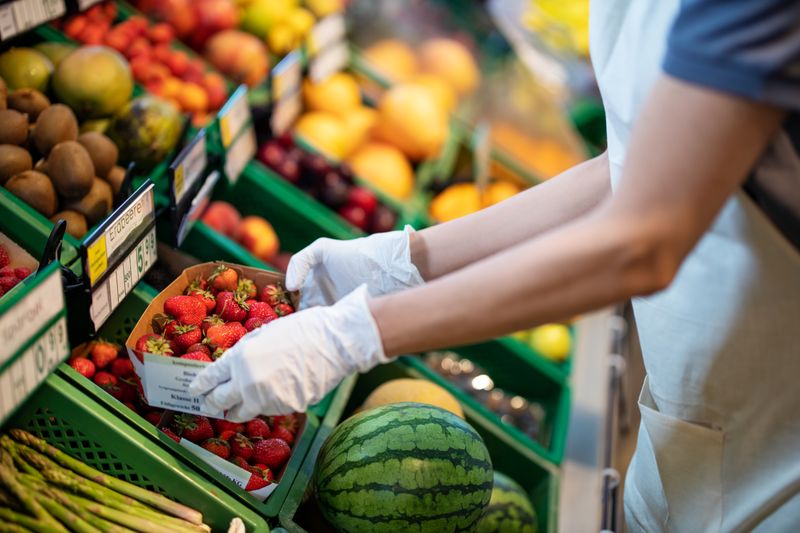 Une personne fixe des aliments entiers dans un supermarché. | Source : Getty Images