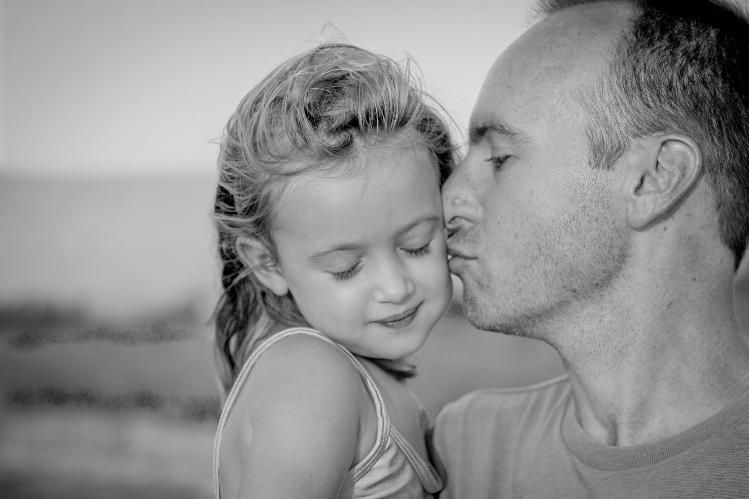 Père embrassant sa fille sur la joue | Source : Unsplash