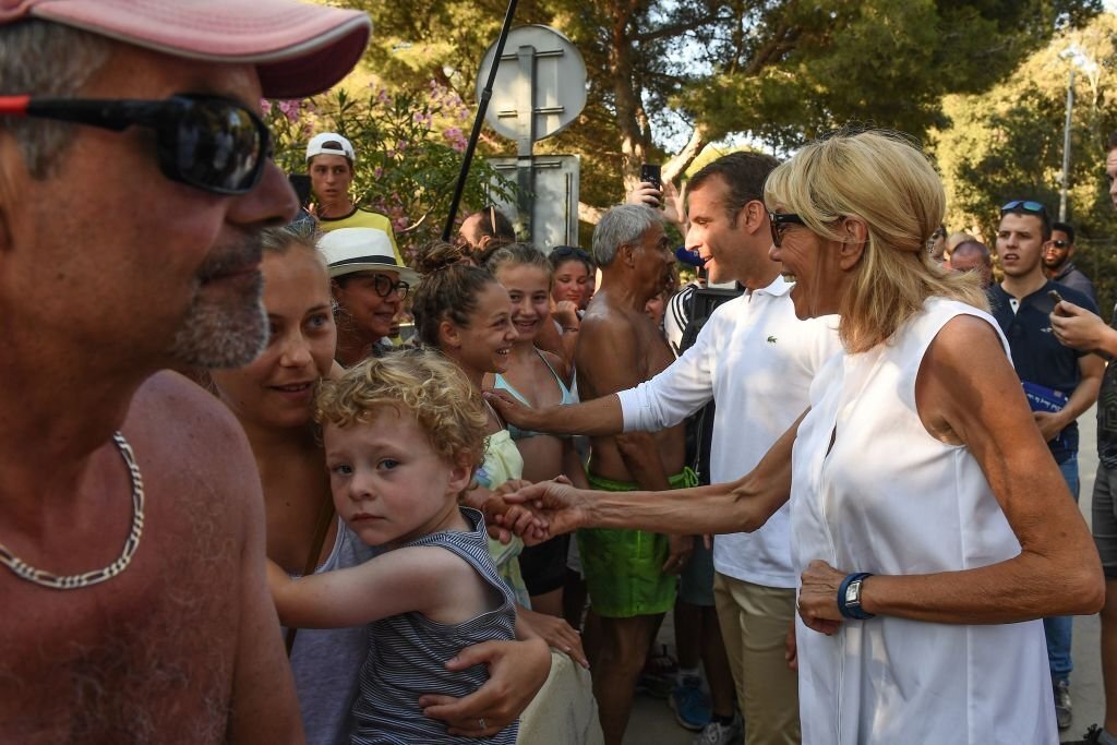 Emmanuel Macron et son épouse Brigitte rencontrent des gens lors d'une promenade le 7 août 2018 à Bormes-les-Mimosas, dans le sud-est de la France. | Photo : Getty Images