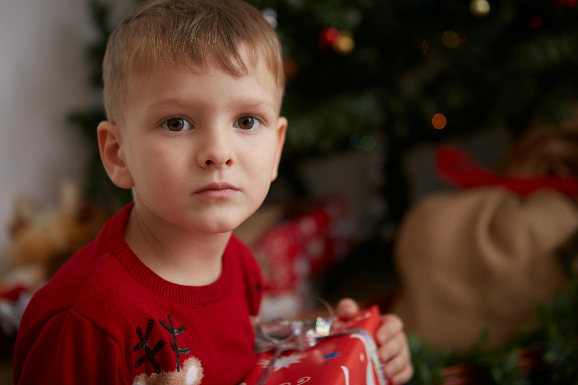 Un garçon qui a l'air confus avec un cadeau de Noël | Source : Pexels