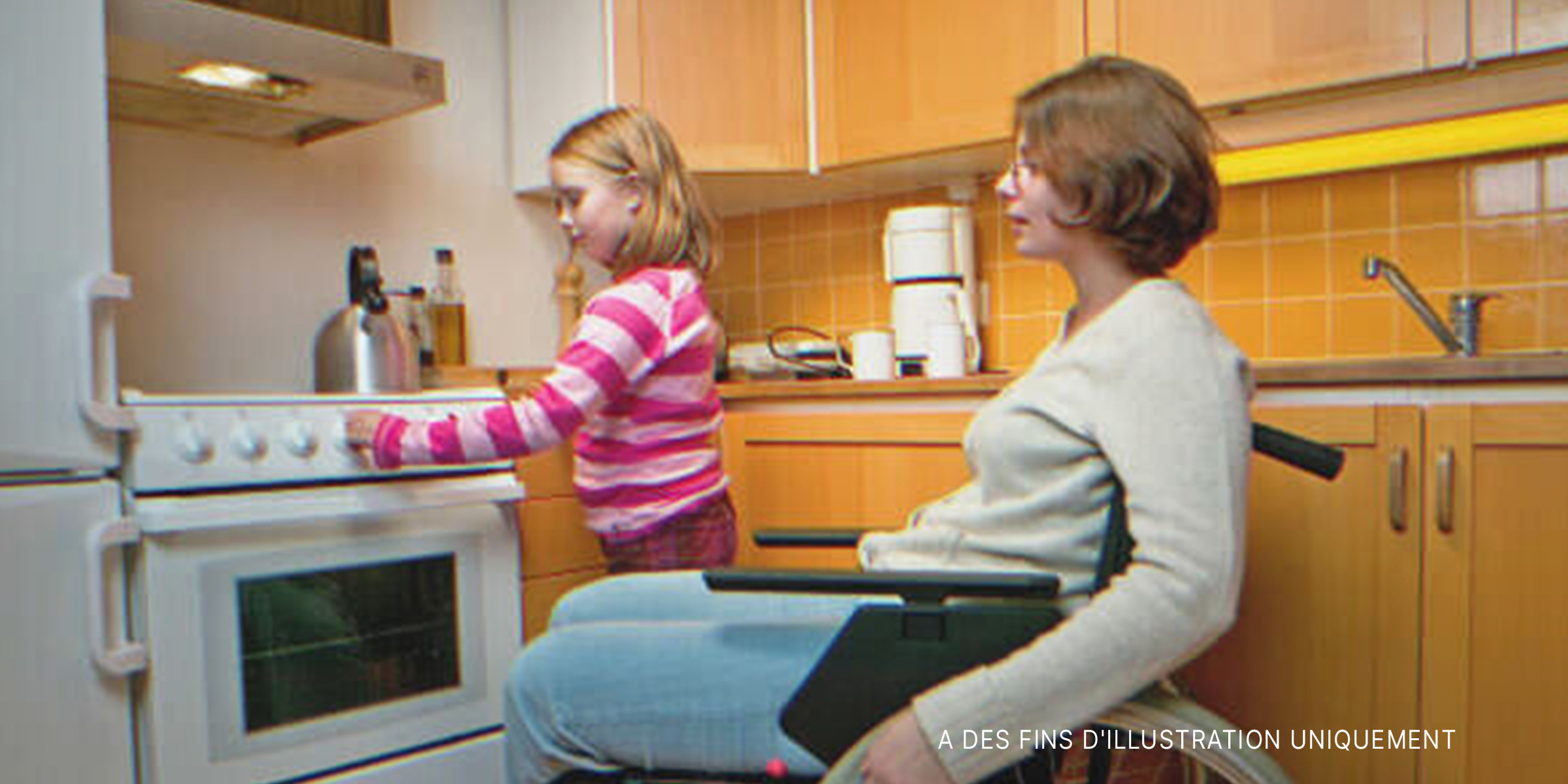 Maman handicapée avec sa fille dans la cuisine | Source : Getty Images