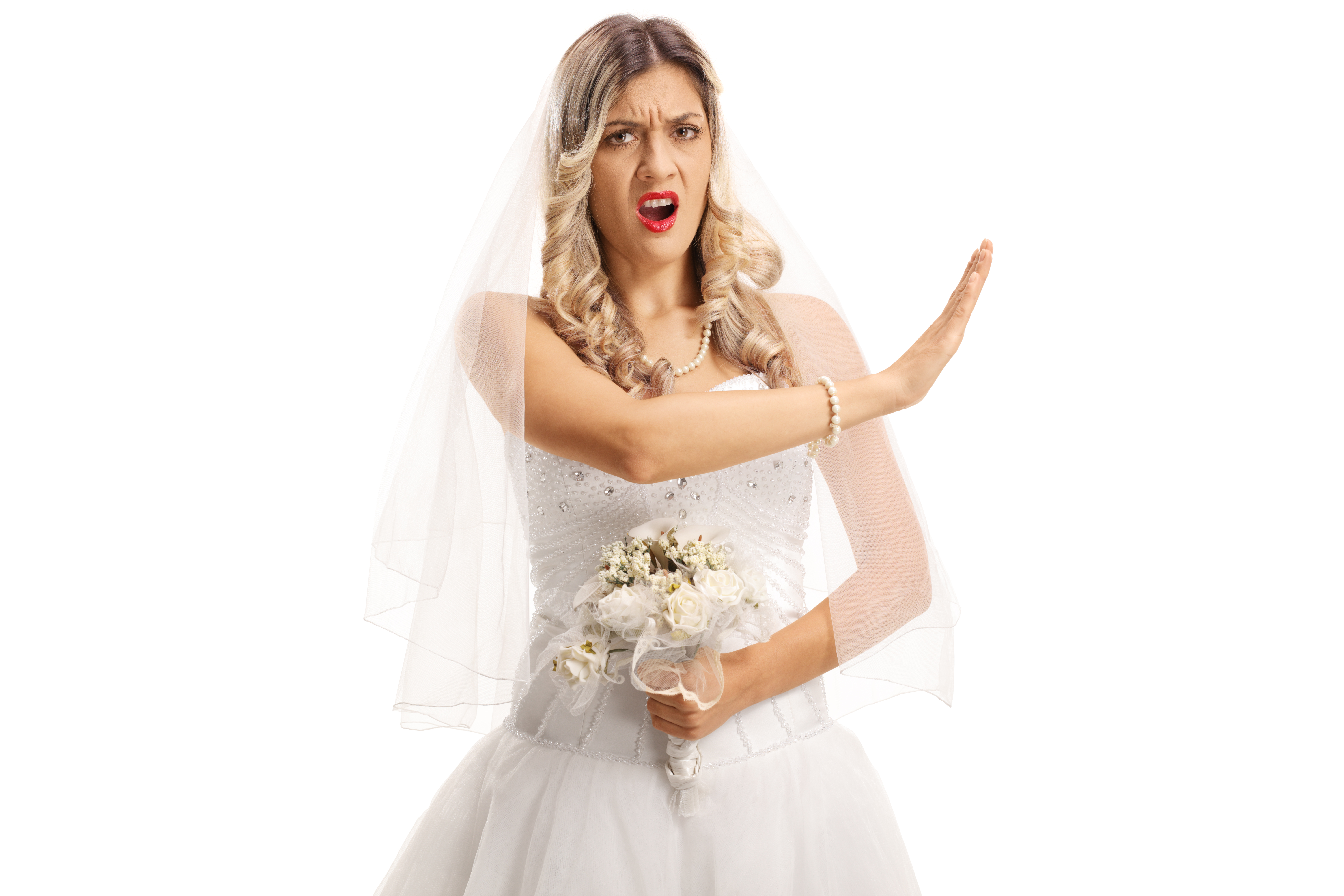 Une mariée en colère qui lève la main vers quelqu'un qui se trouve en dehors du cadre | Source : Shutterstock