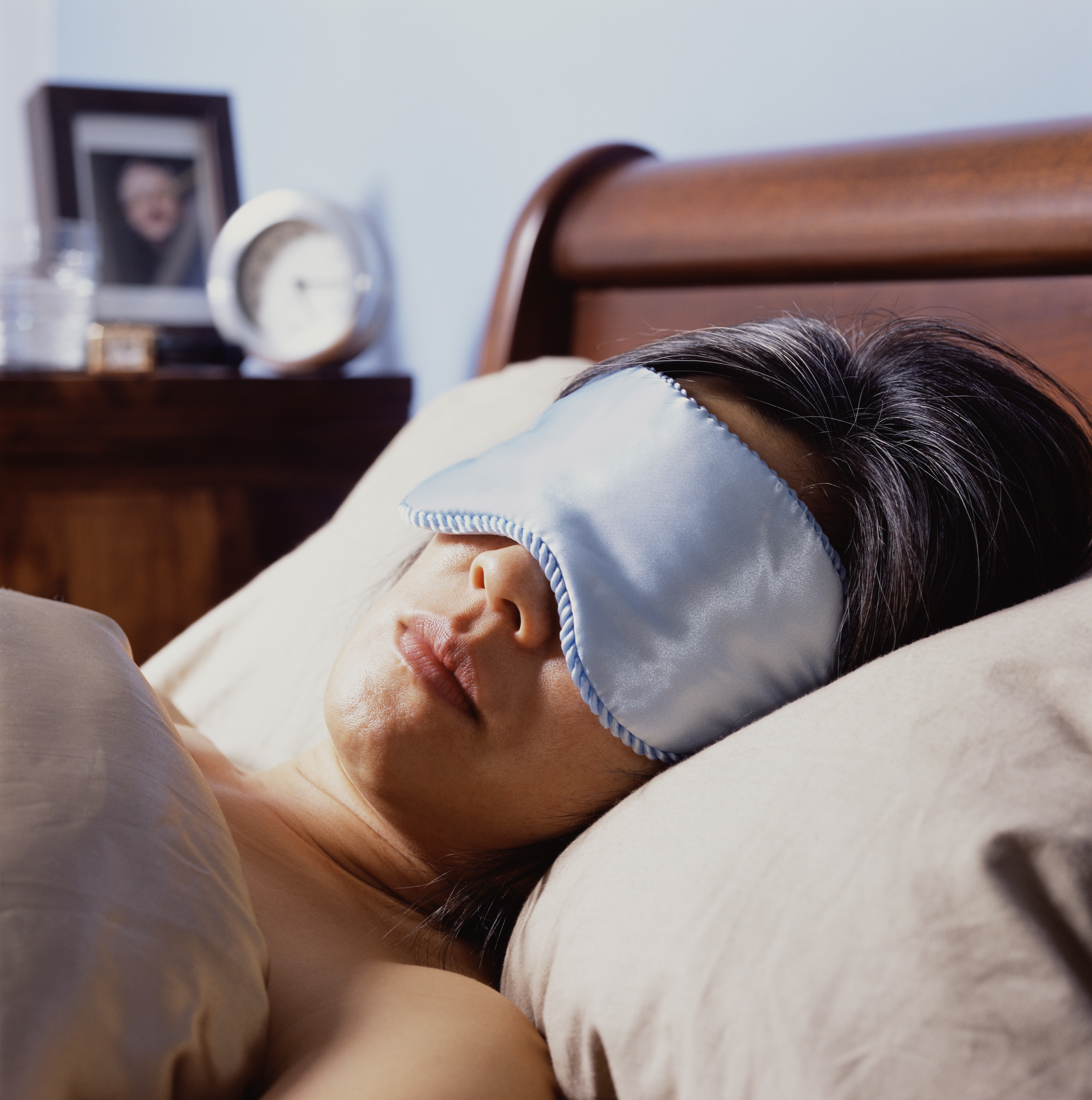 Gros plan sur une femme qui dort avec un masque pour les yeux | Source : Getty Images