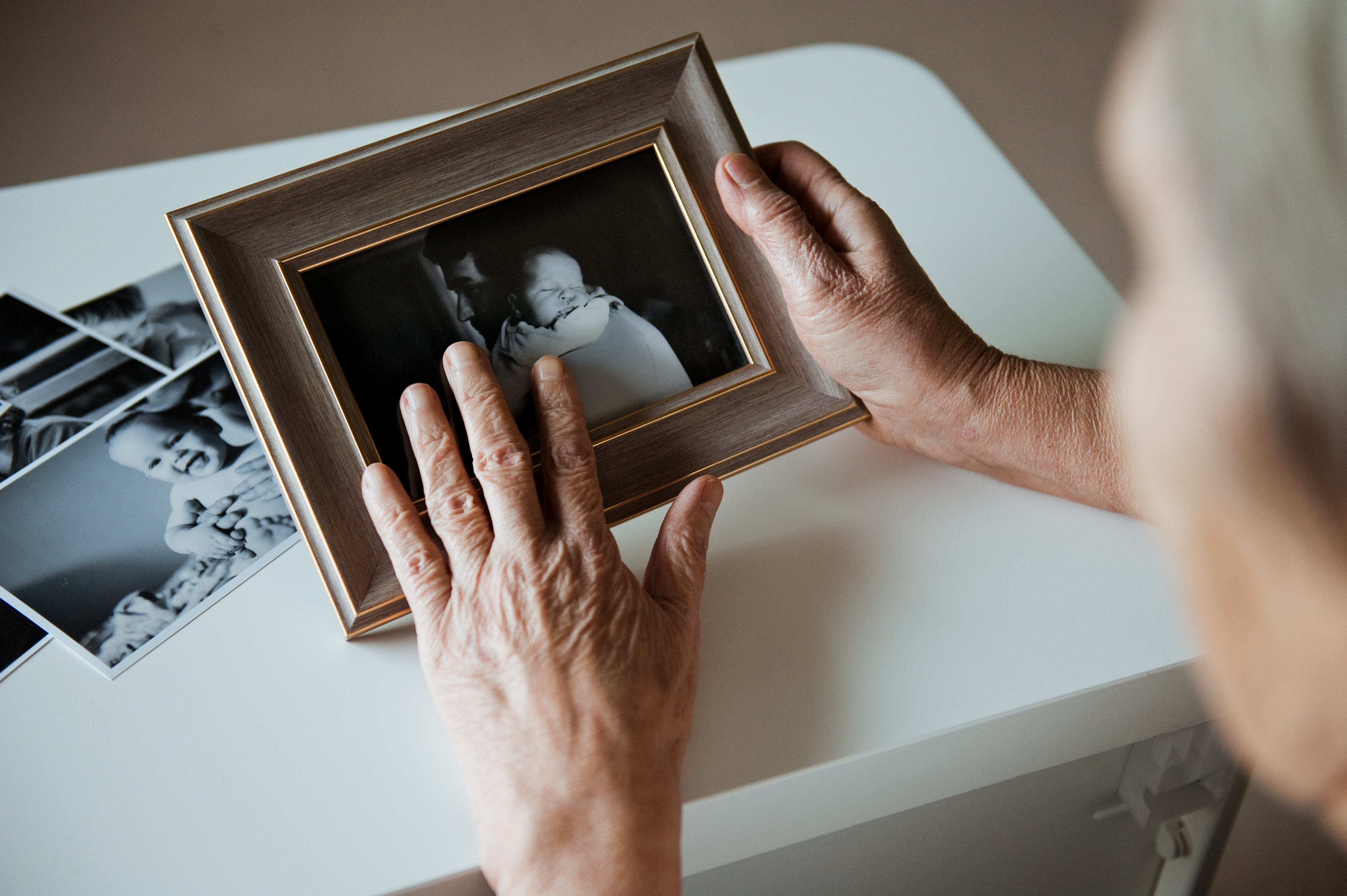 Une femme âgée tenant un cadre photo | Source : Shutterstock