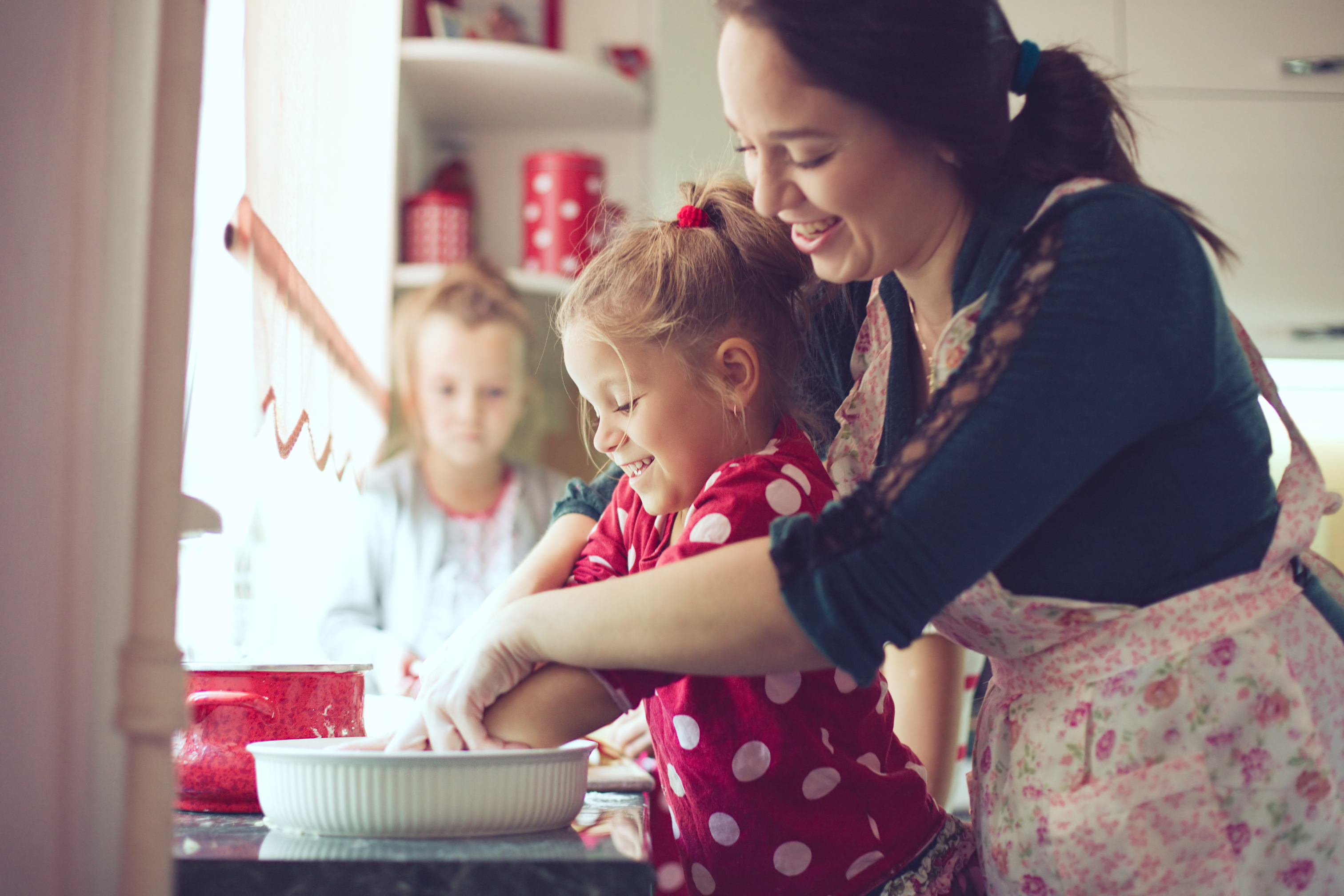 Une mère travaillant dans la cuisine avec ses enfants | Source : Shutterstock