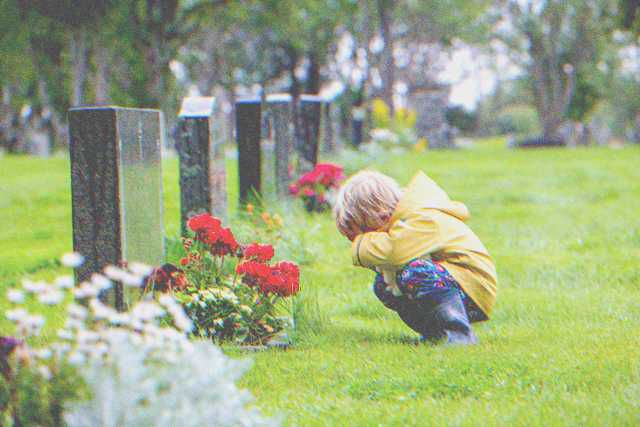 Petit garçon en pleurs près d'une tombe. | Source : Shutterstock