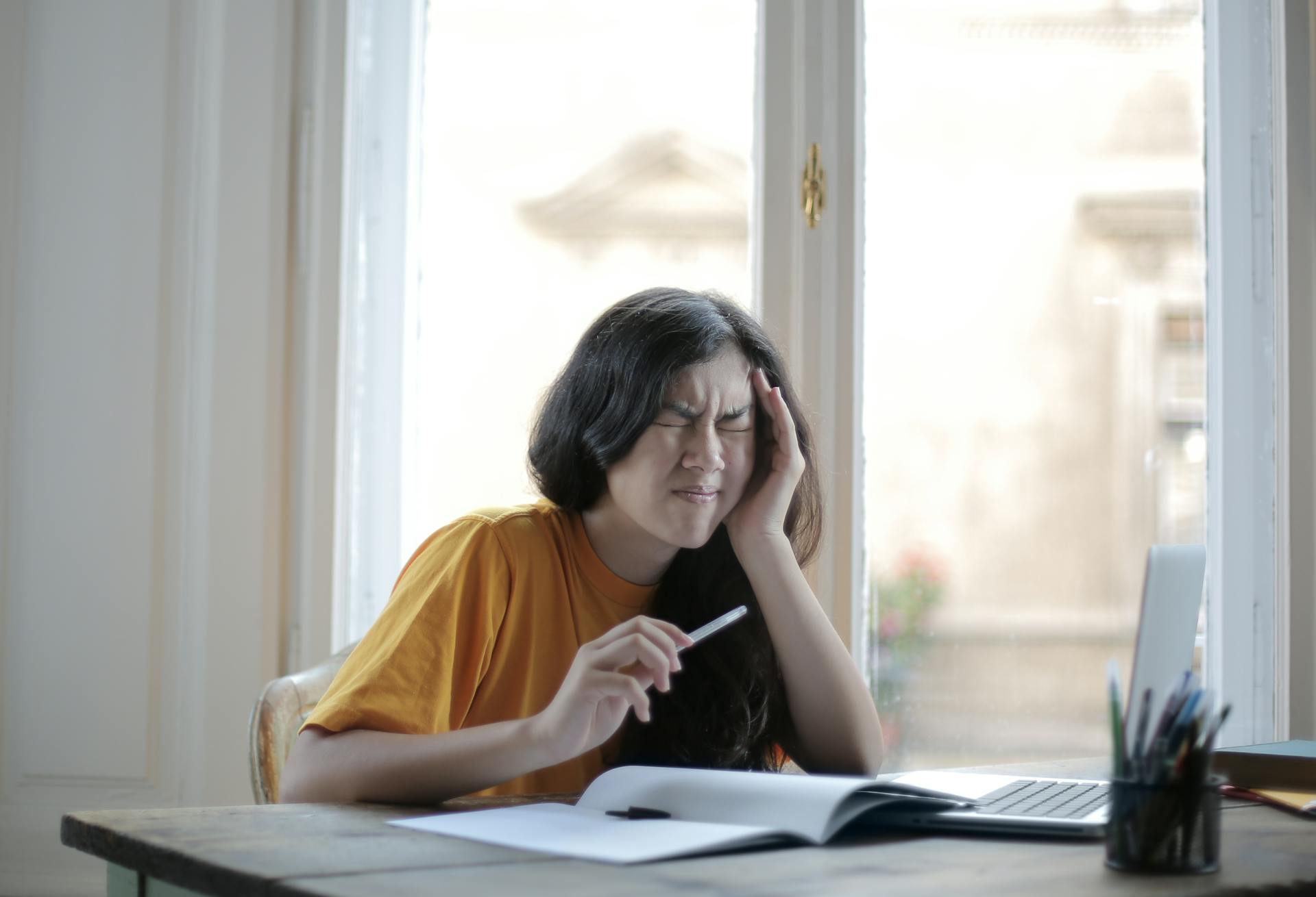 A woman sitting at a desk, making a face | Source: Pexels