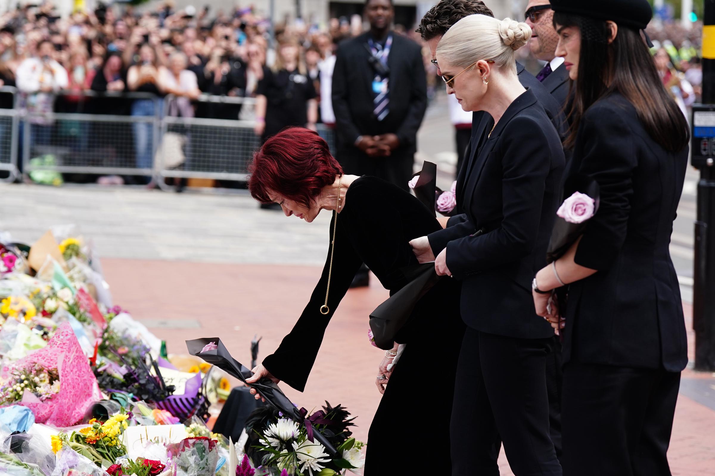 La famille Osbourne regarde les messages et les hommages floraux laissés sur le pont de Black Sabbath à Birmingham le 30 juillet 2025 | Source : Getty Images