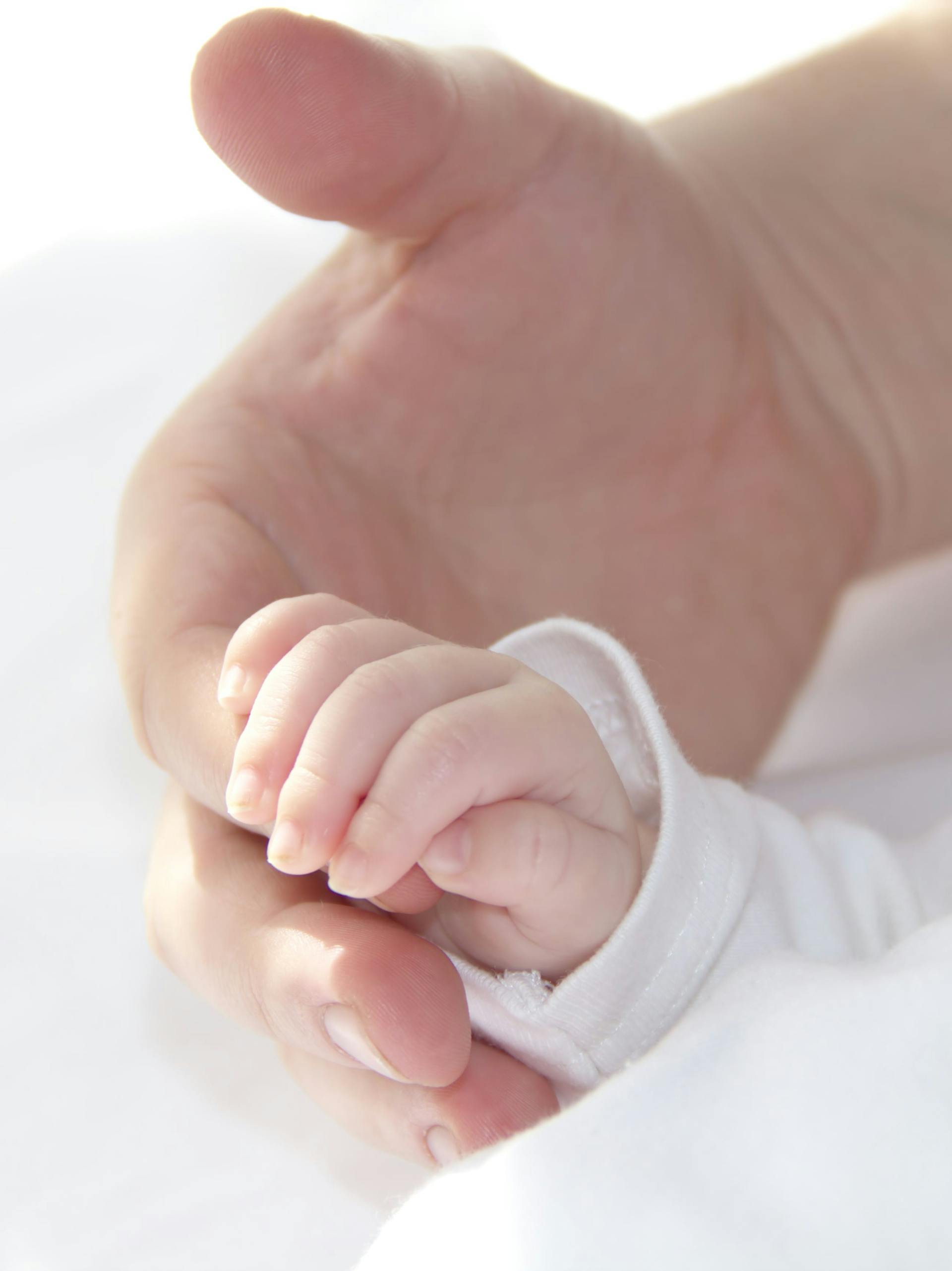 Un bébé tenant le doigt d'un homme | Source : Pexels