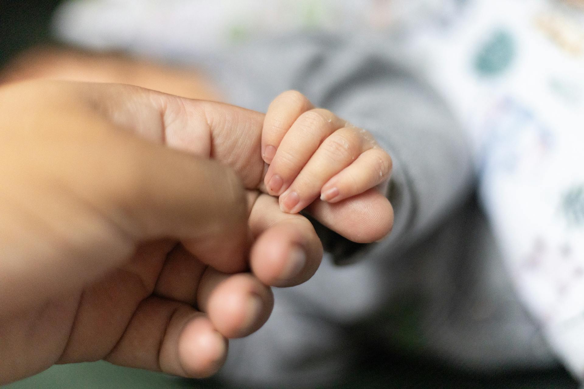 Un bébé tenant le doigt d'un homme | Source : Pexels