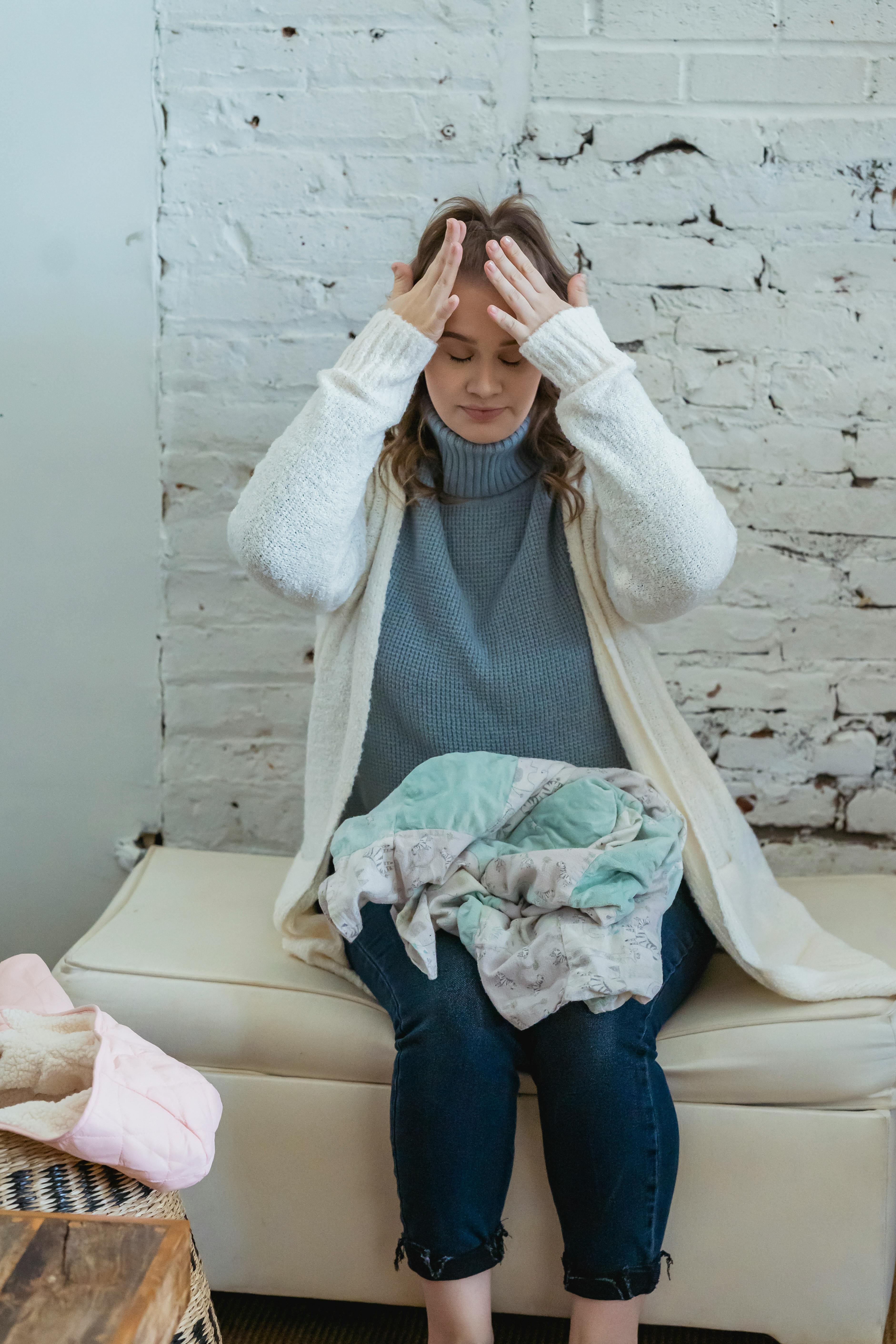 Femme se frottant le front avec ses mains en signe de frustration | Source : Pexels