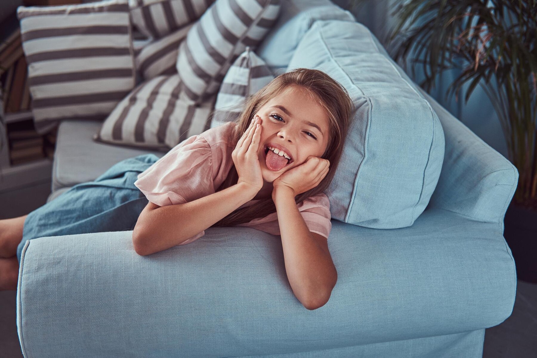 A happy girl on a couch | Source: Freepik