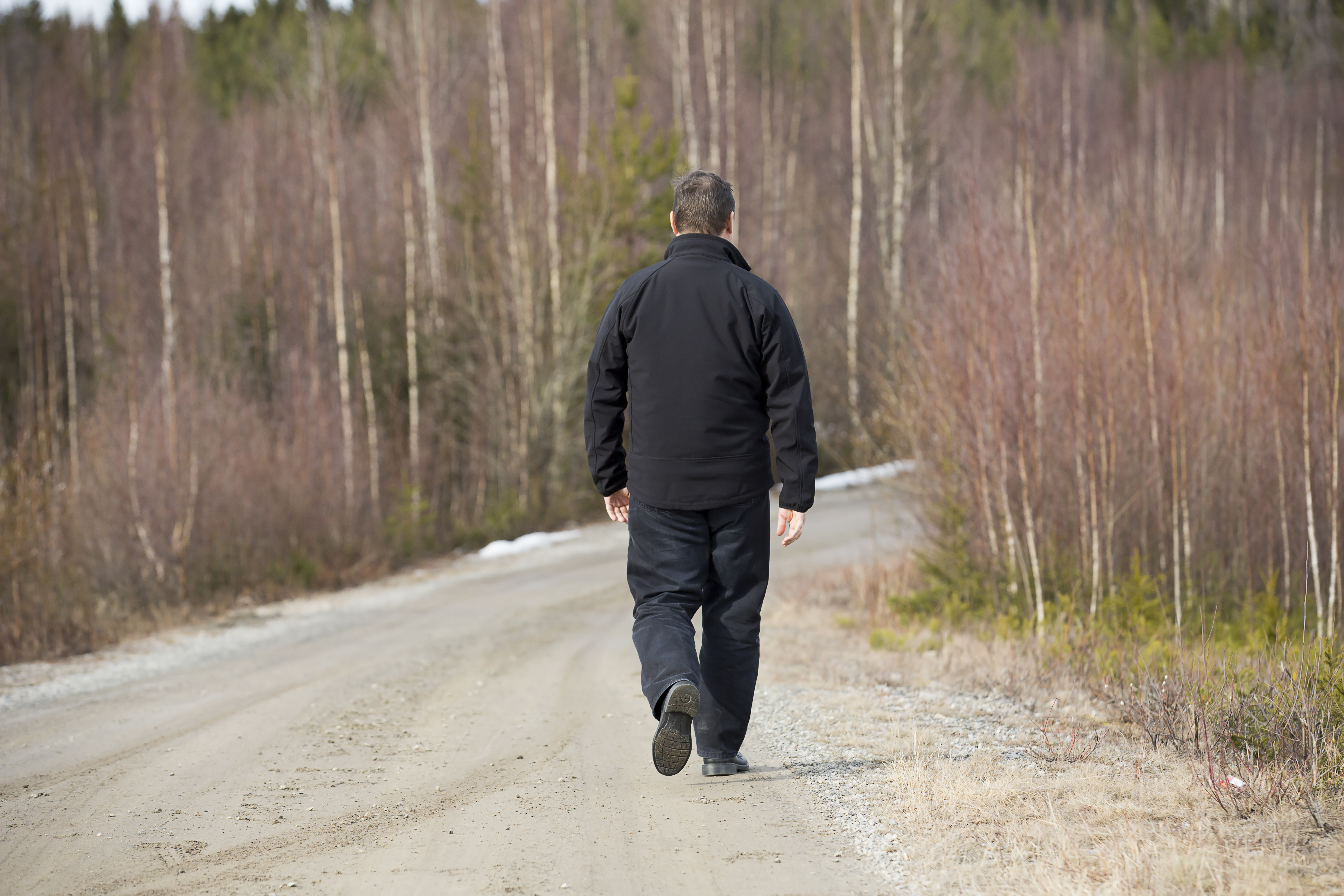 Homme marchant sur la route. | Source : Shutterstock
