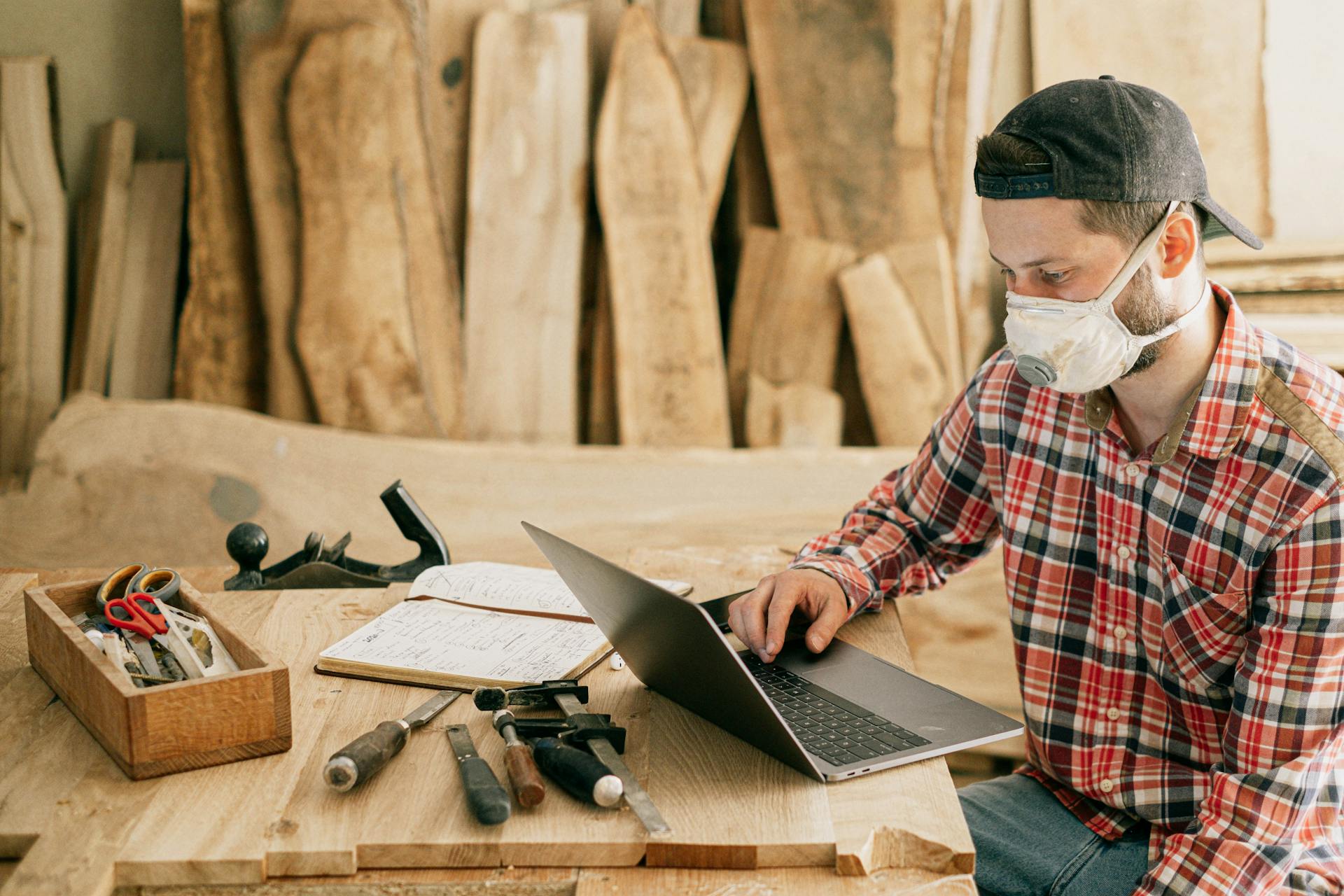Un homme utilisant un ordinateur portable dans un atelier de menuiserie | Source : Pexels