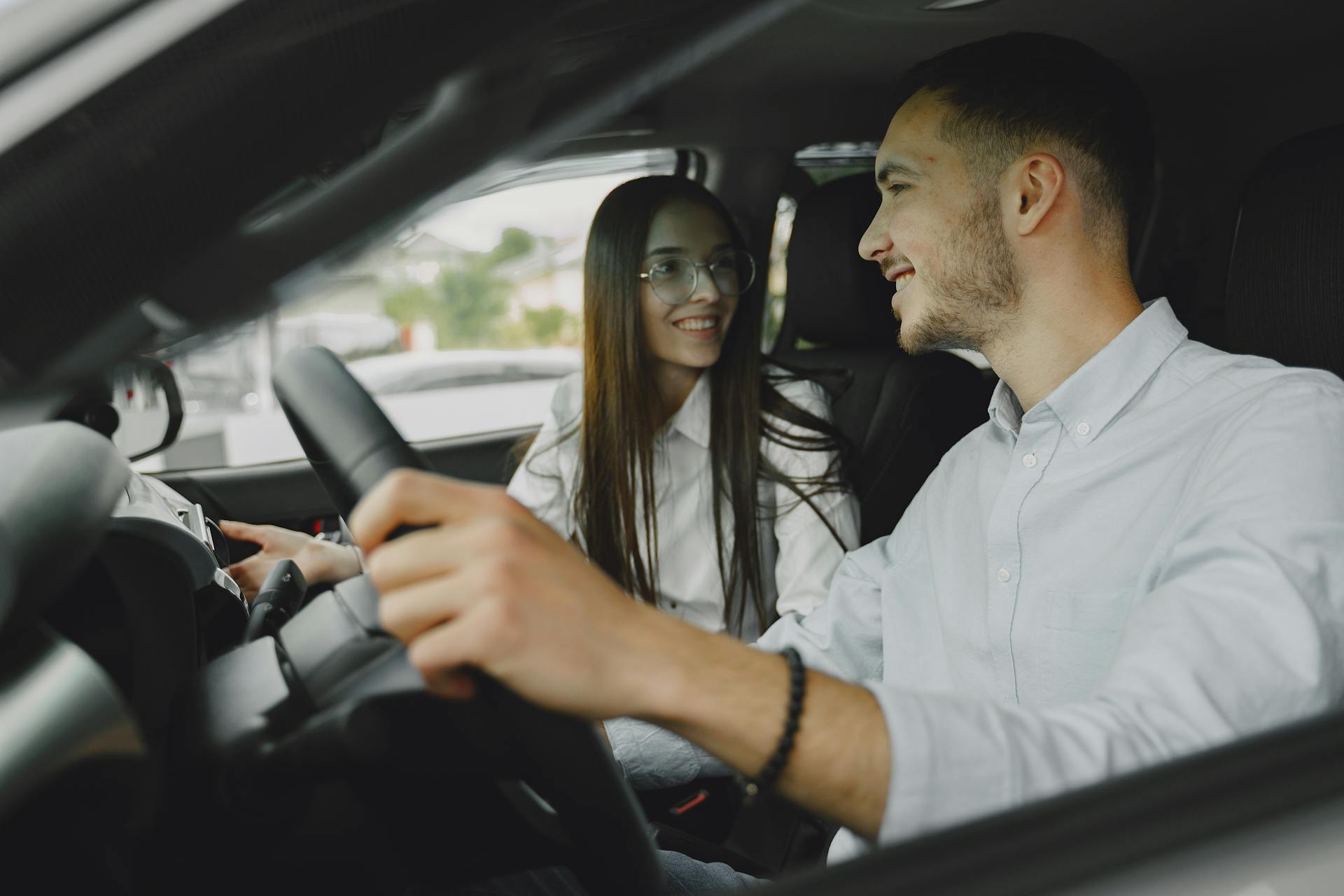 Un couple heureux assis dans une voiture | Source : Pexels