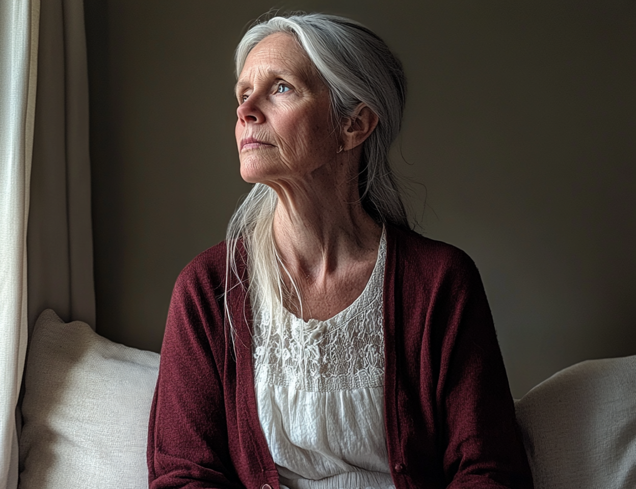 Une femme âgée qui regarde par la fenêtre | Source : Midjourney