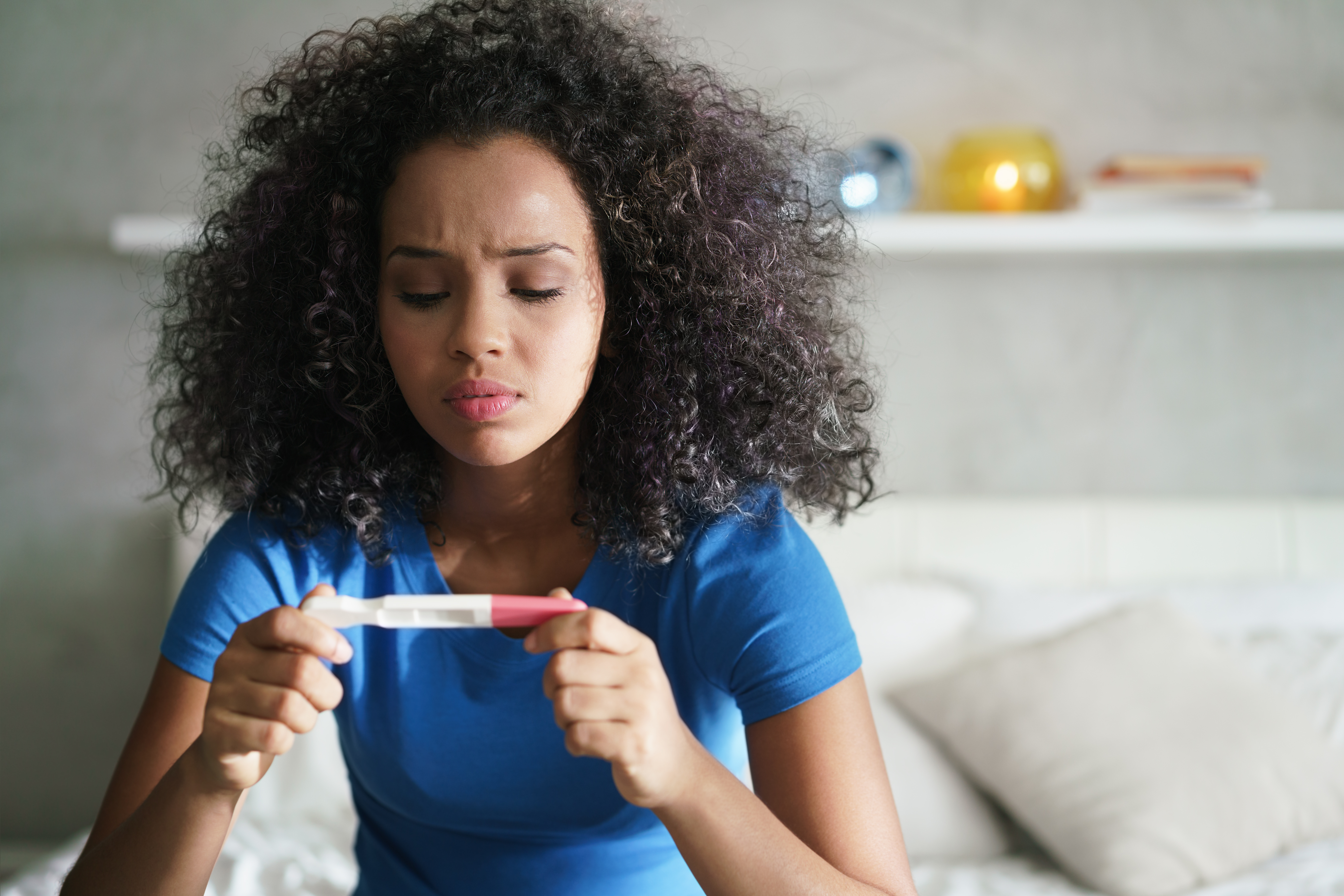 Menina com teste de gravidez em seu quarto | Fonte: Shutterstock.com