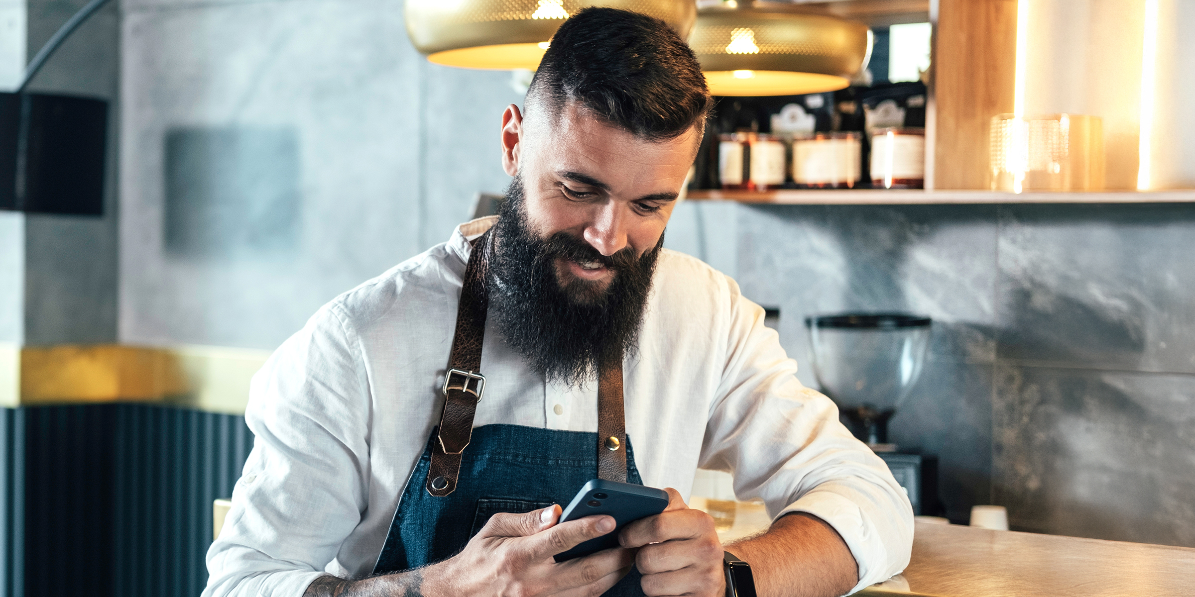 Un homme qui regarde son téléphone en riant | Source : Shutterstock