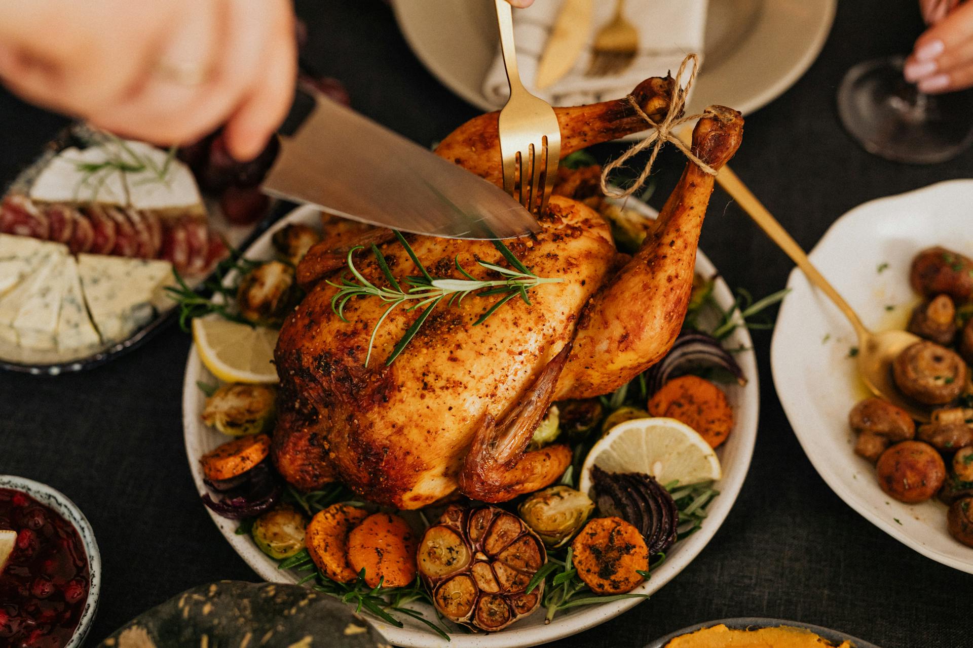 Une personne découpant du poulet rôti | Source : Pexels