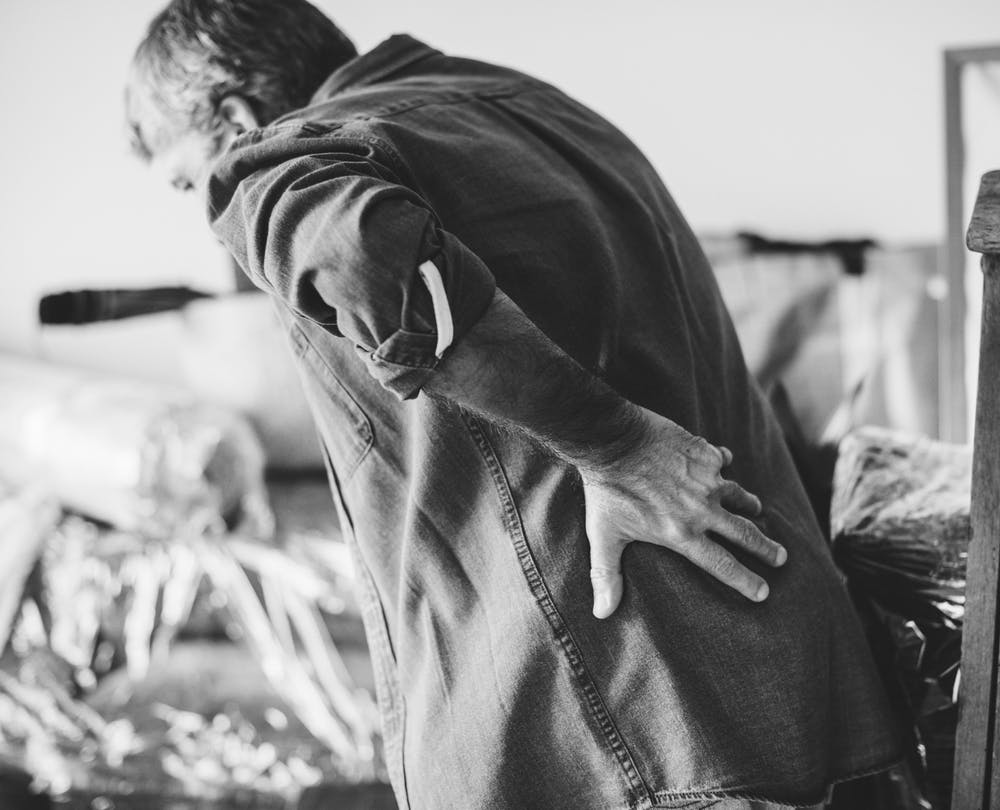 Un homme tenant son dos douloureux. | Photo: Pexels