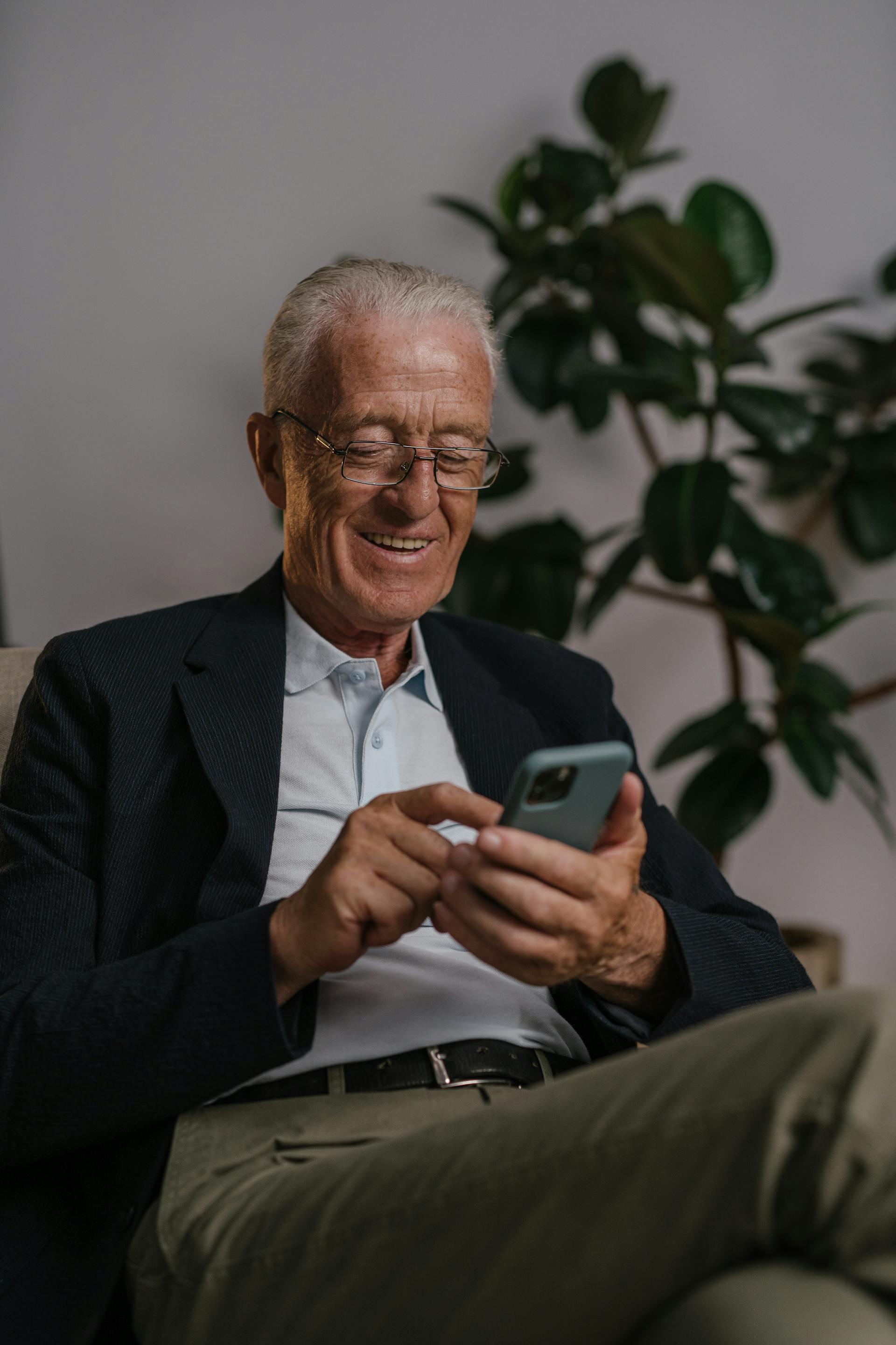 Un homme heureux sur son téléphone | Source : Pexels