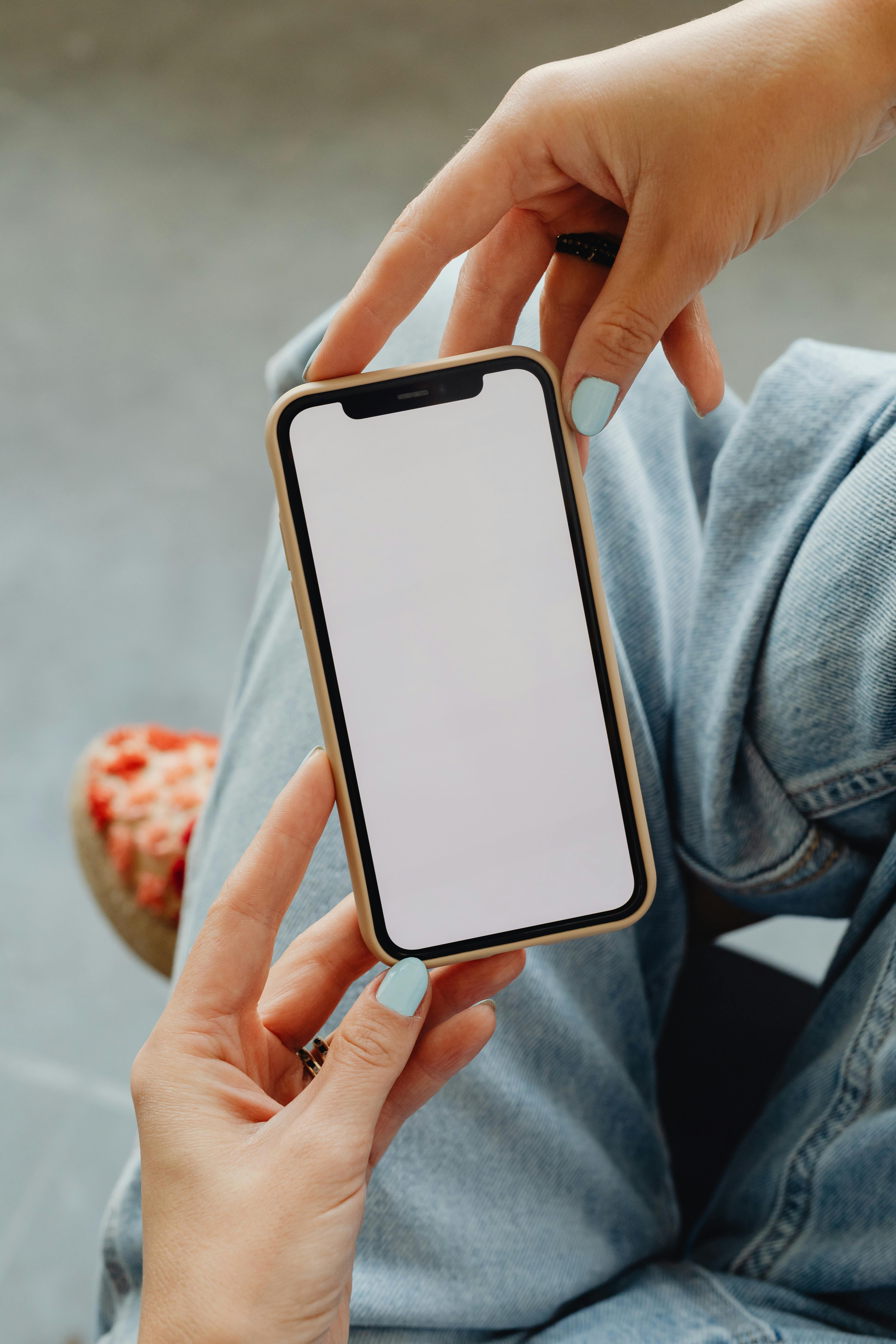 Une femme tient un smartphone dans ses mains | Source : Pexels