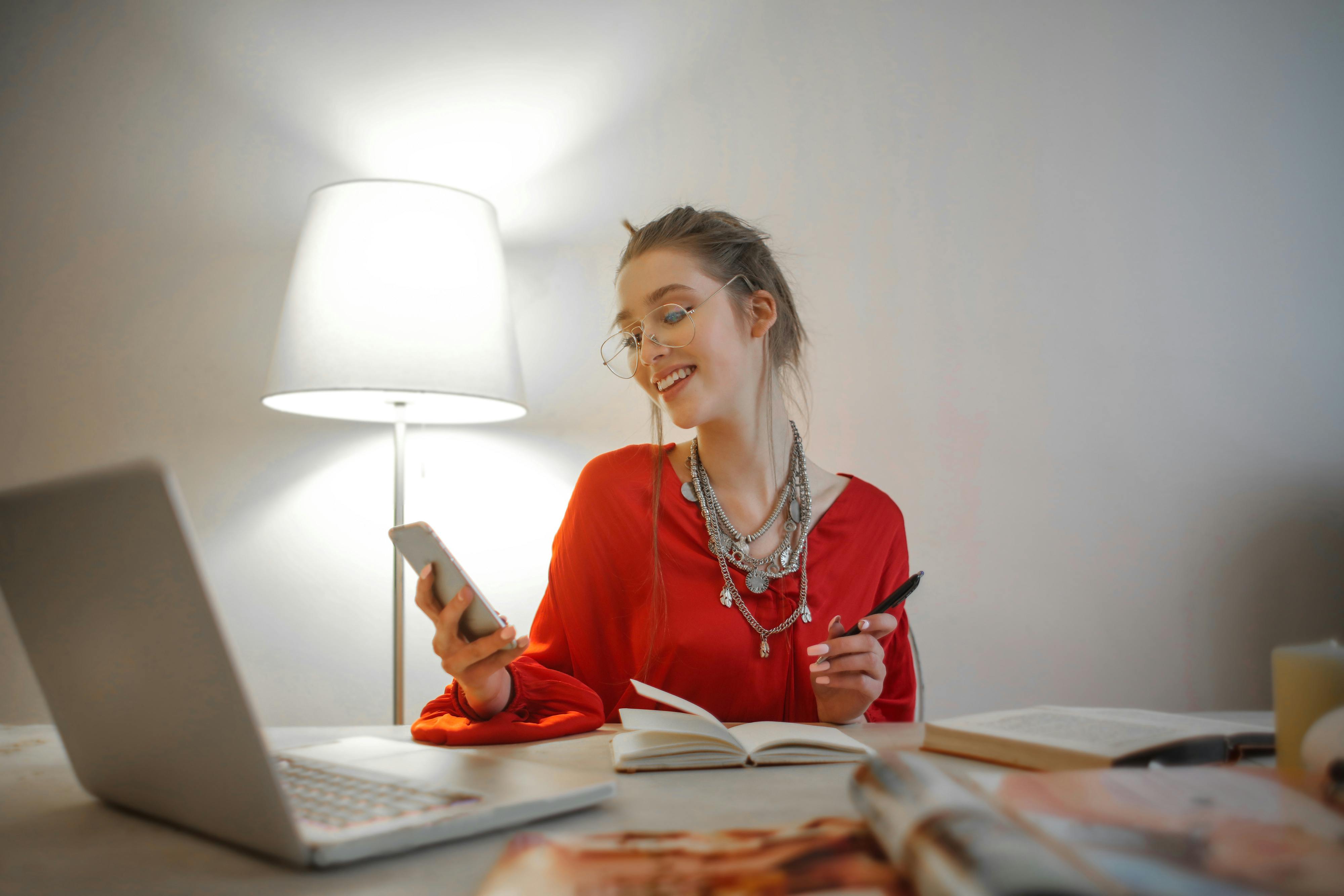 Une femme souriant tout en tenant un téléphone portable | Source : Pexels