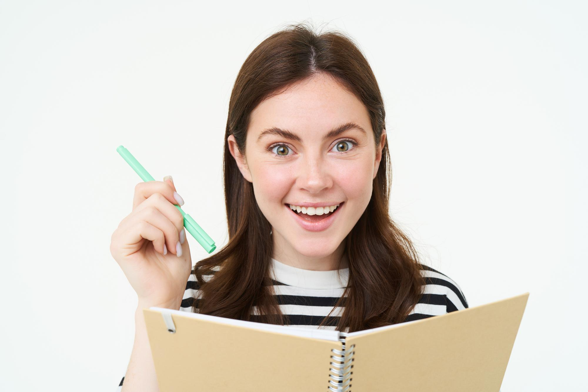 Une femme tenant un stylo et un cahier | Source : Freepik