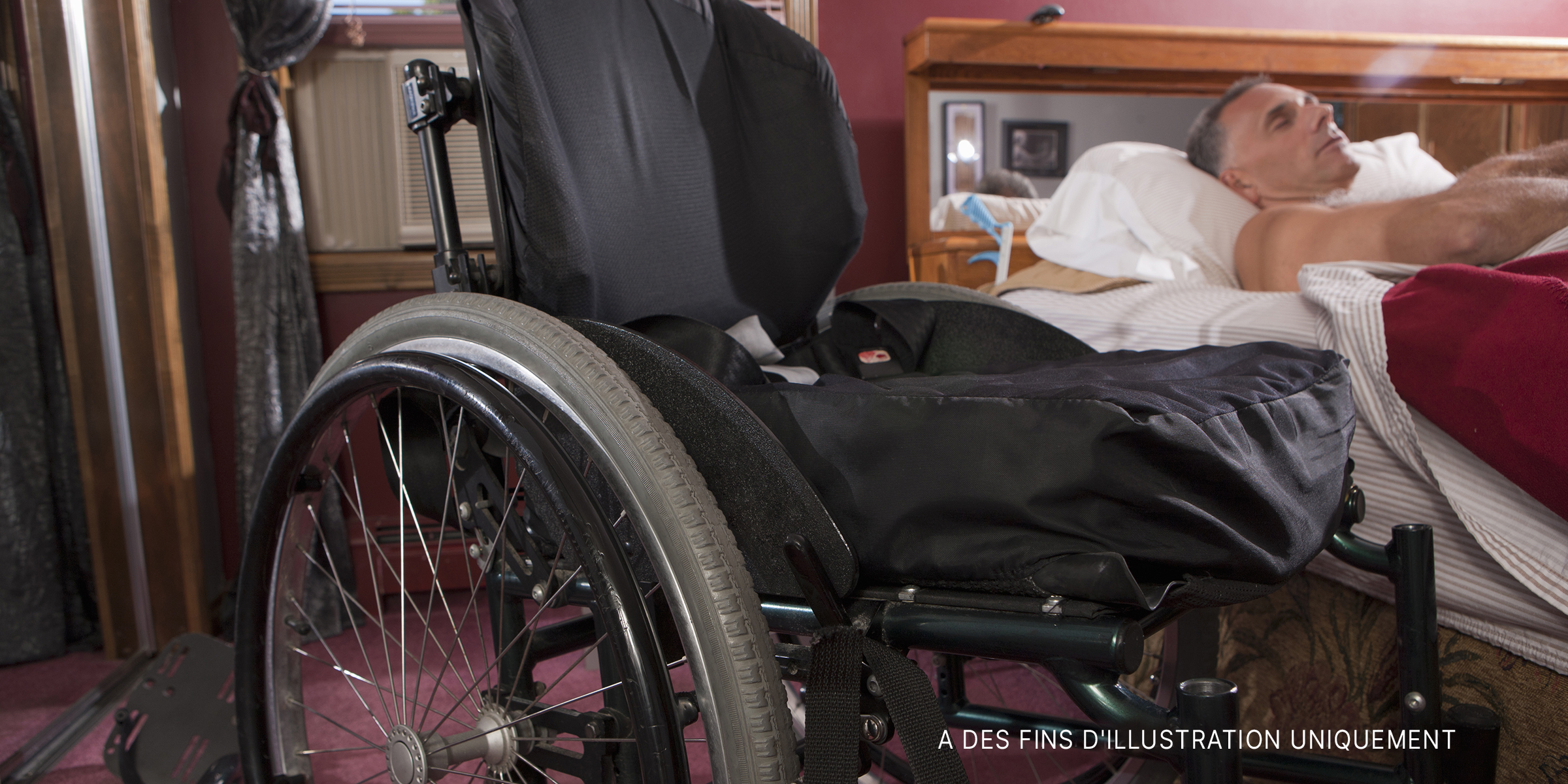 Un homme âgé handicapé dormant à côté d'un fauteuil roulant | Source : Getty Images
