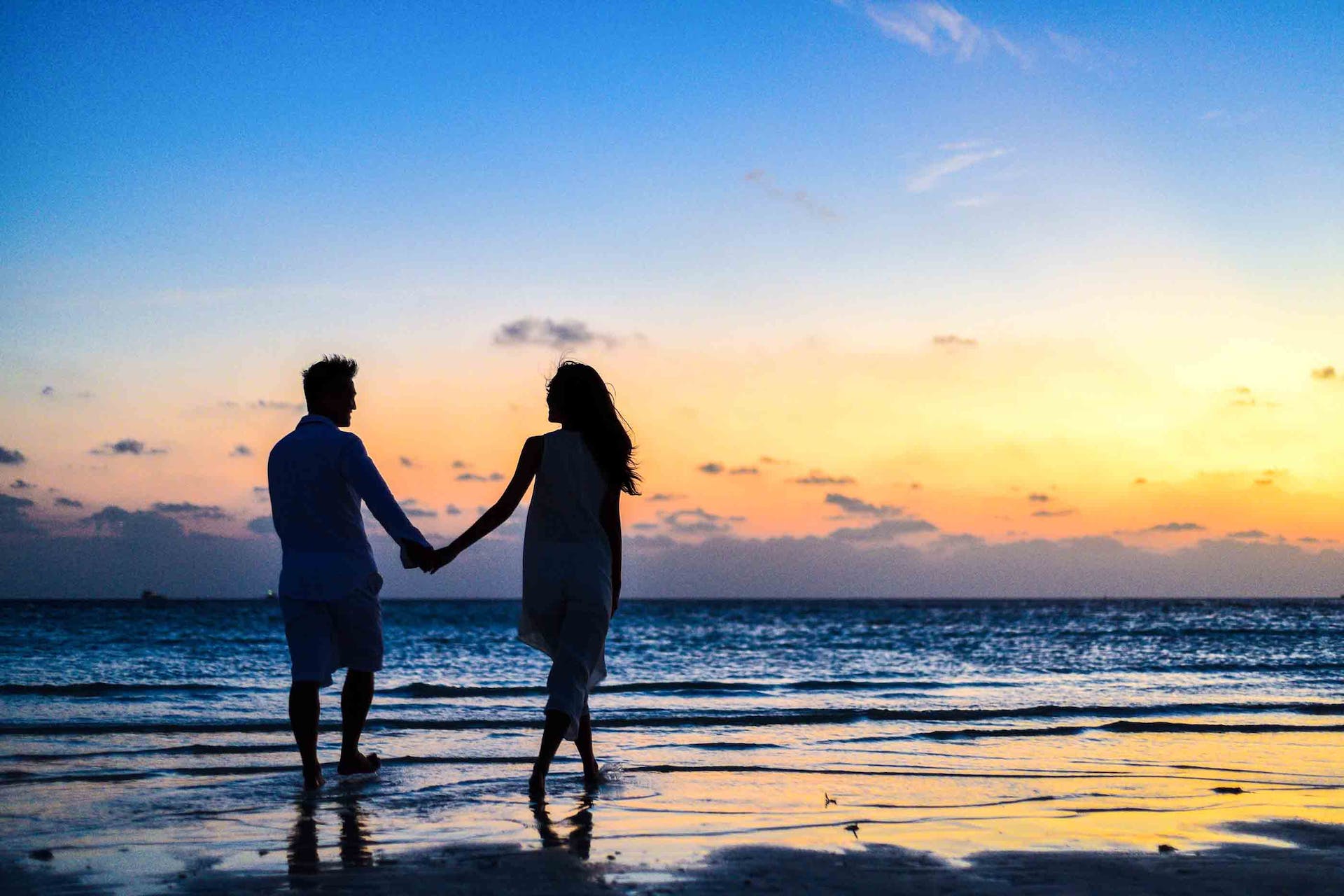 Um casal andando na praia | Fonte: Pexels