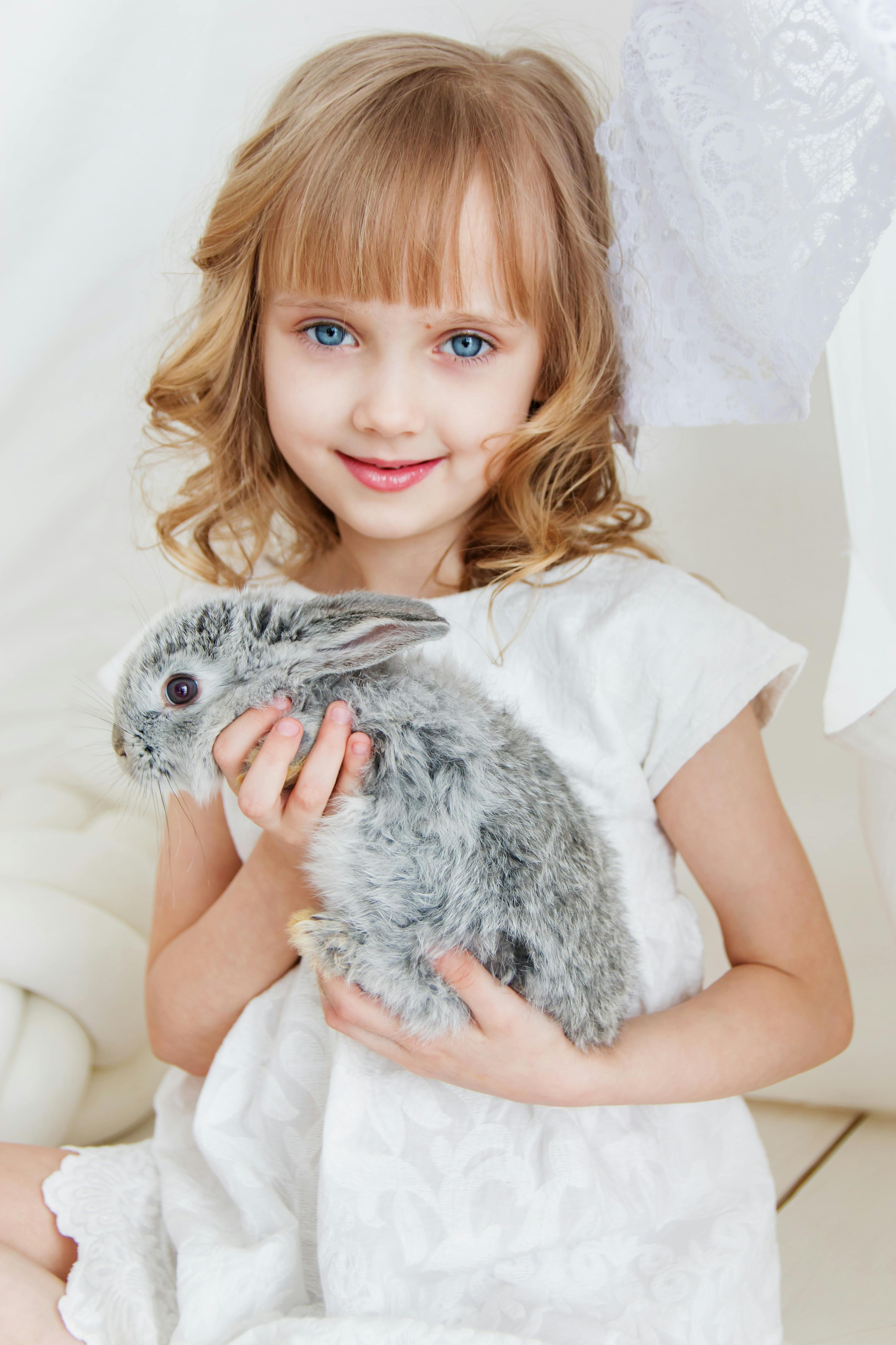 Une fille souriante tenant un lapin | Source : Pexels